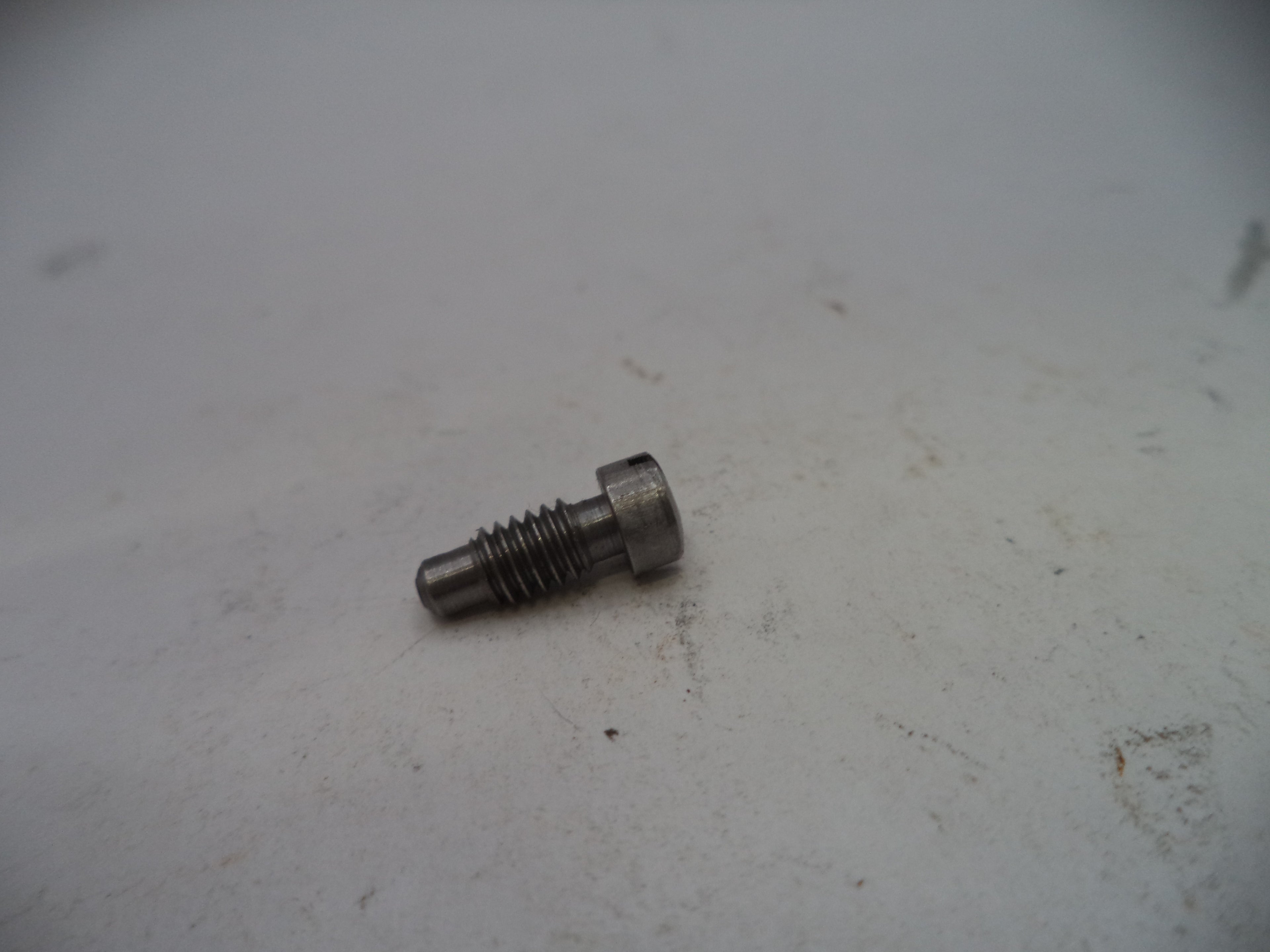 Metal screw on a worn white surface