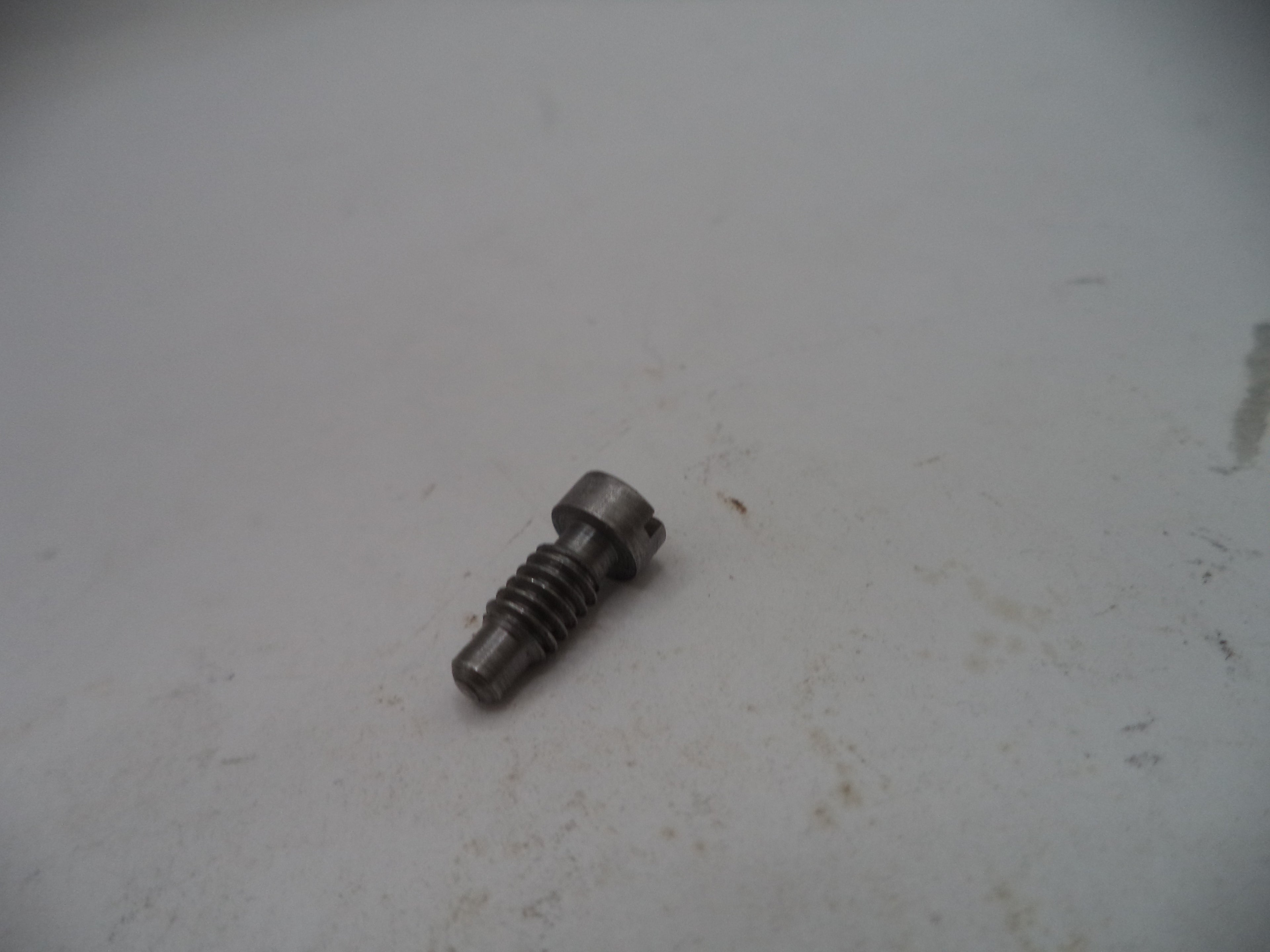 Metal screw on a textured white surface