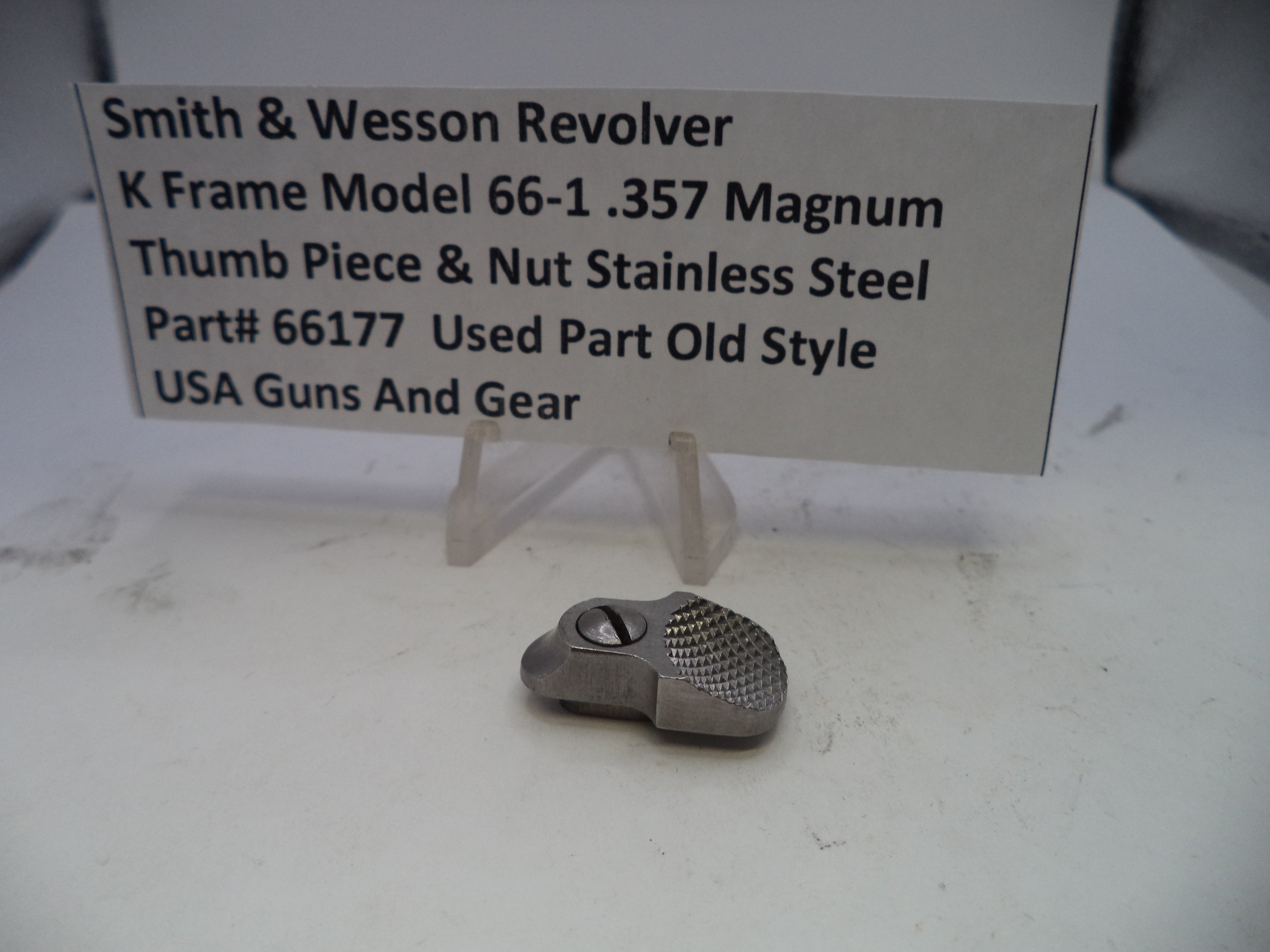 Smith & Wesson revolver thumb piece and nut on a display card with product details.
