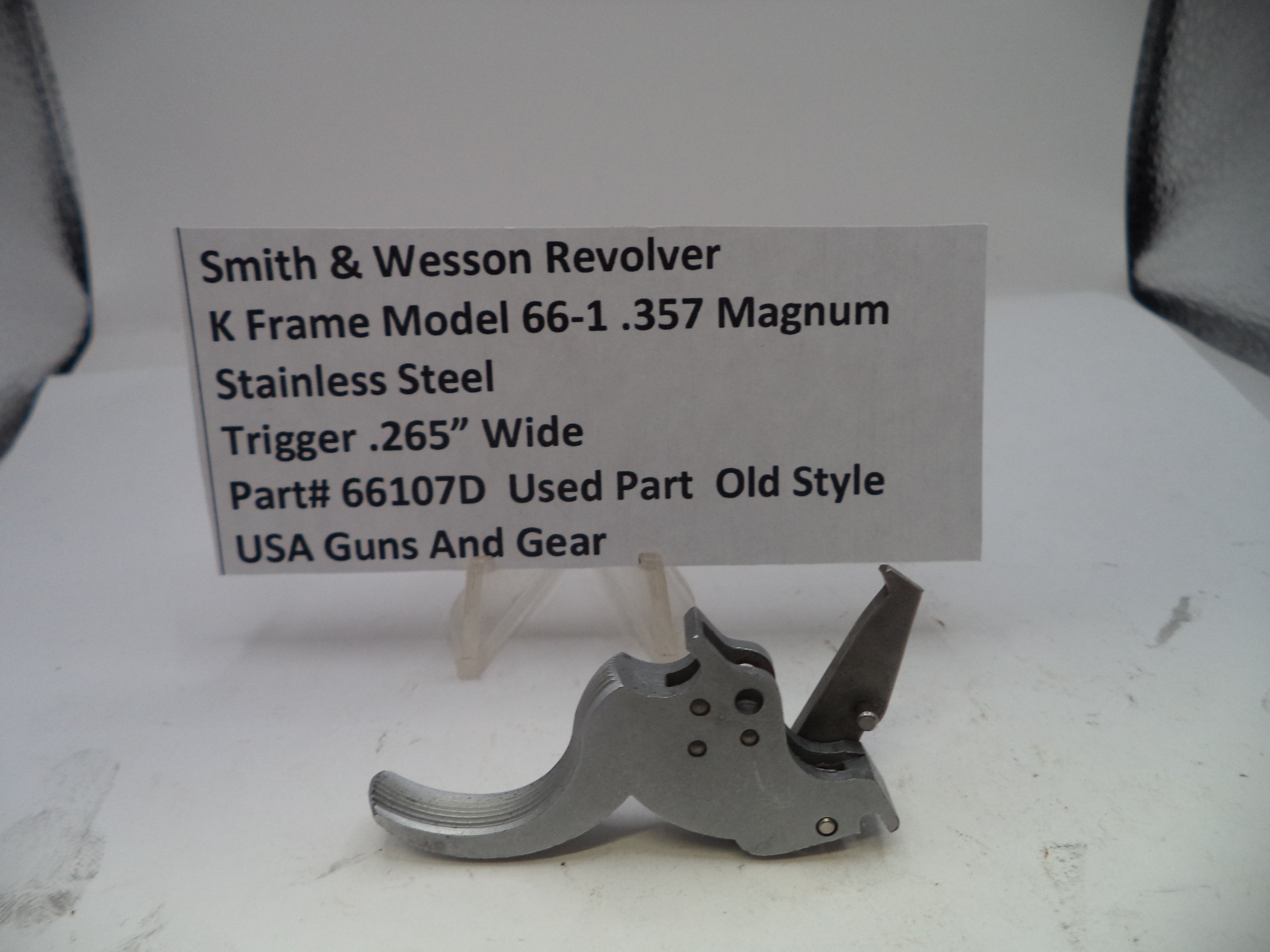 Smith & Wesson revolver trigger part on a white background with descriptive label.