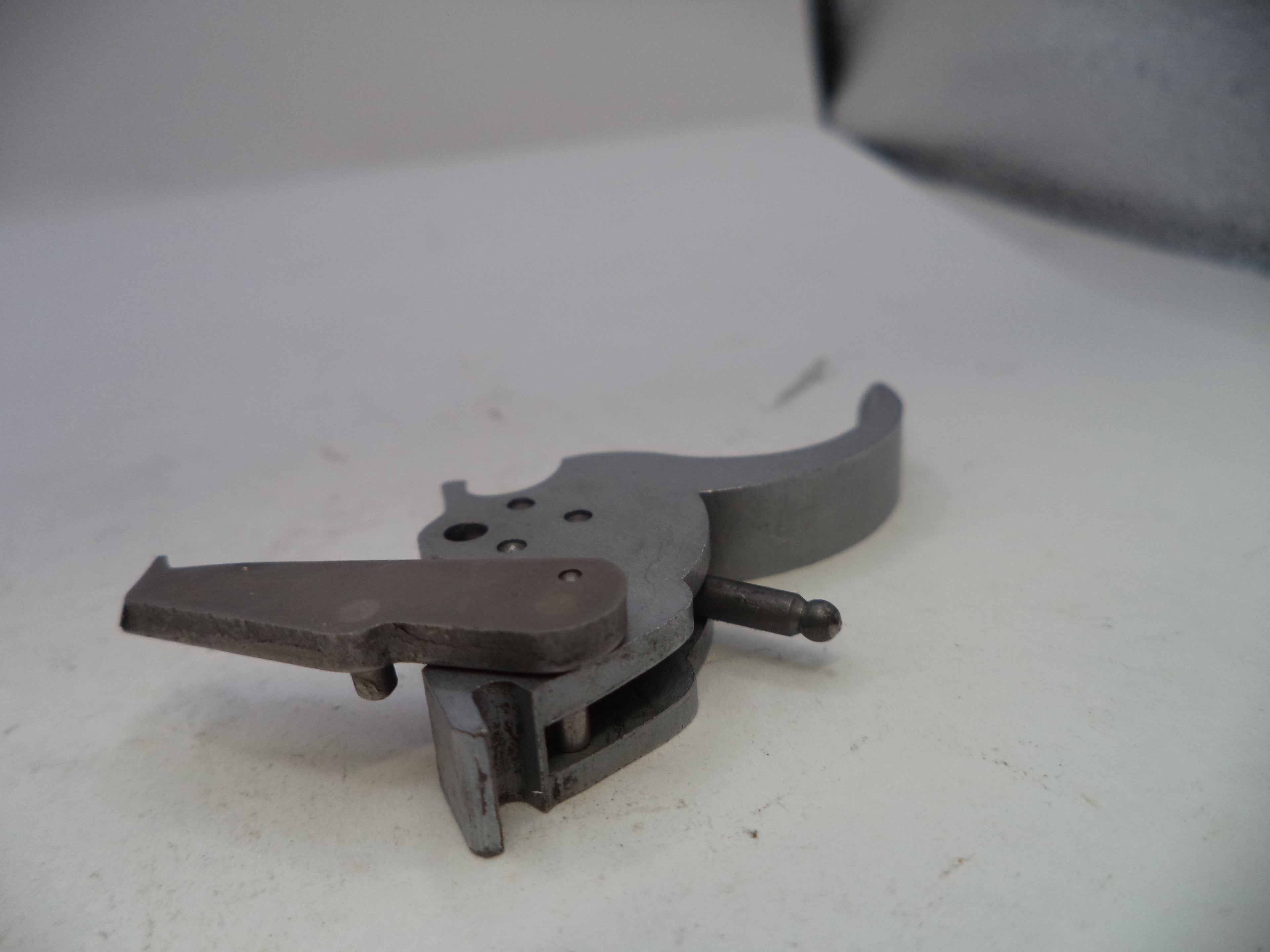Metal tool or component on a white surface