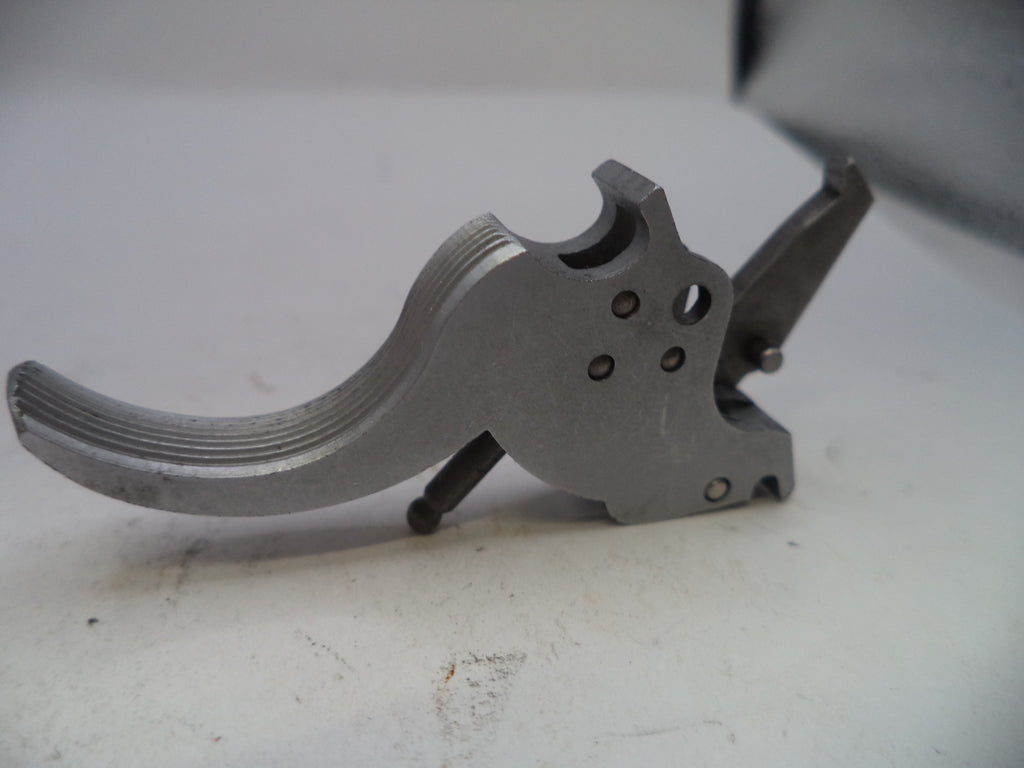Metallic firearm trigger on a white surface