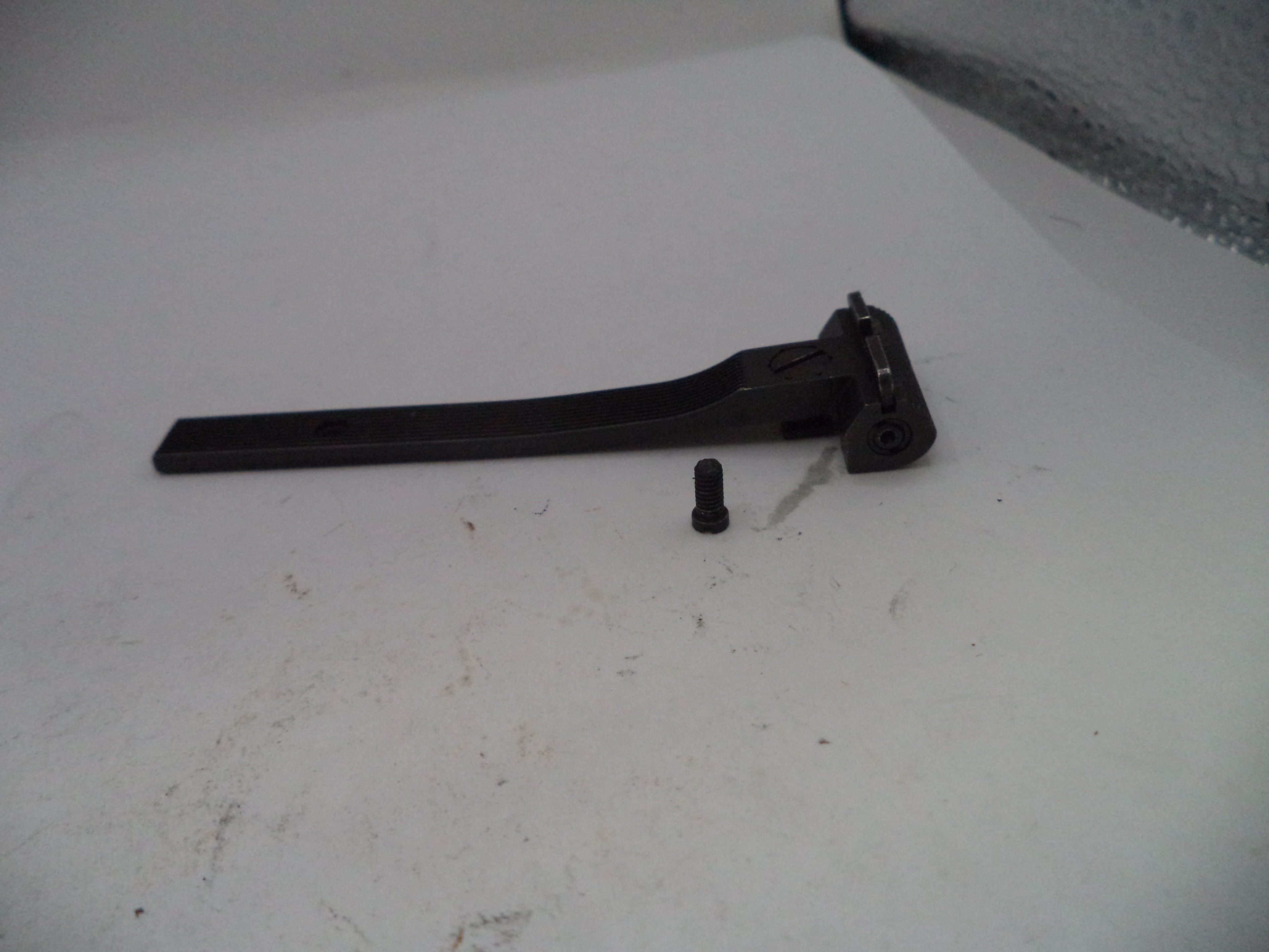 Black metal lever and cylindrical component on a white surface
