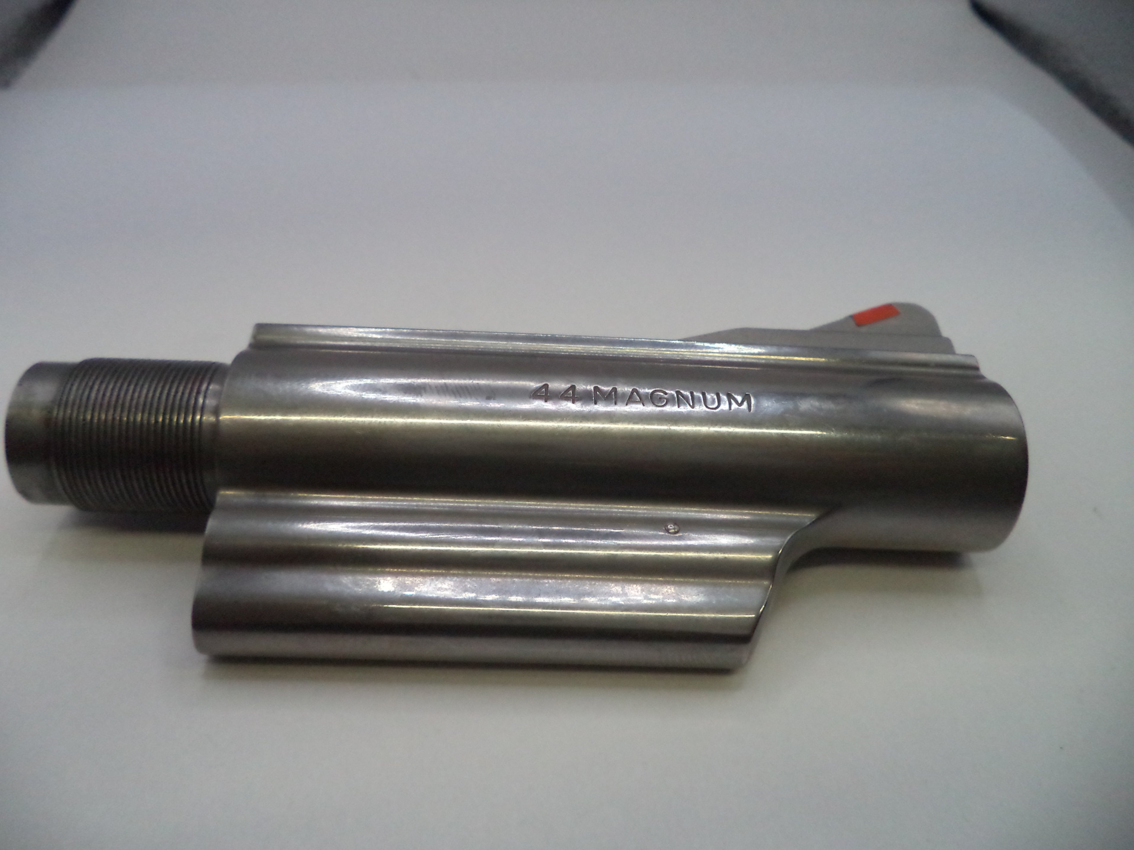 Metal cylindrical component with '14 Magnum' marking on a white surface