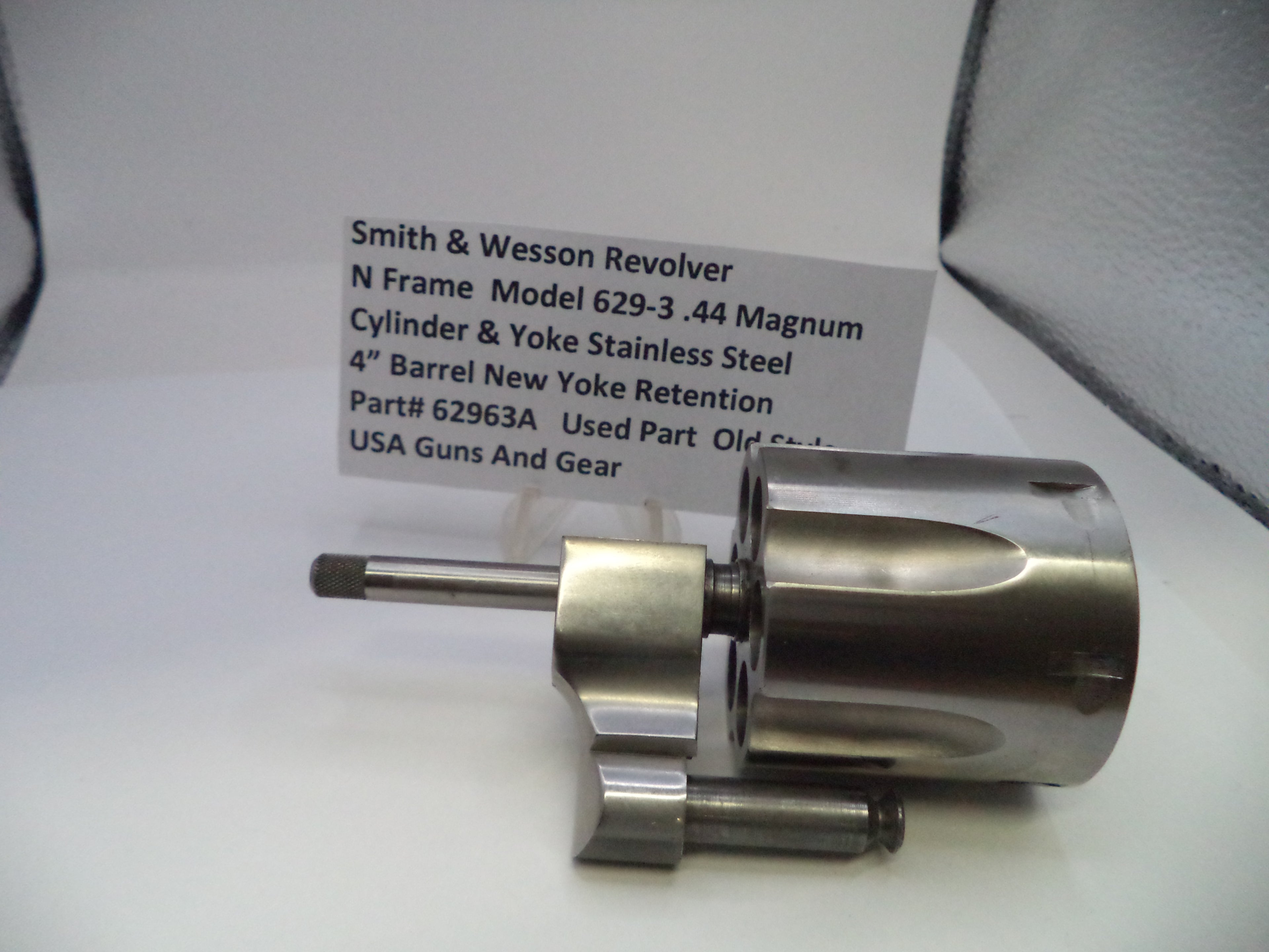 Smith & Wesson revolver cylinder and yoke retention part with a label on a white surface