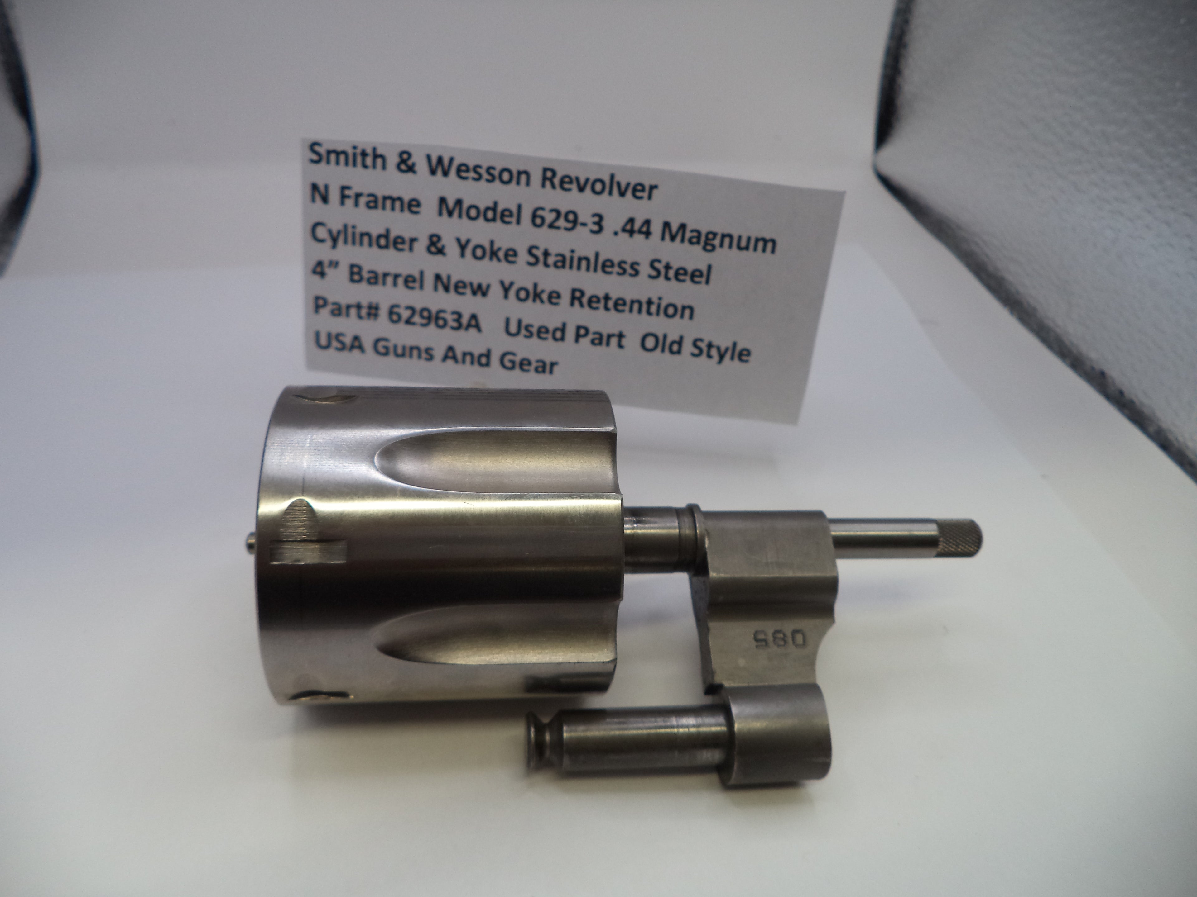 Smith & Wesson revolver cylinder and yoke on a white surface with a label.