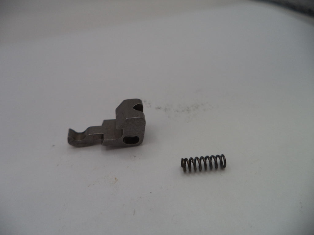 Metal component and spring on a white surface