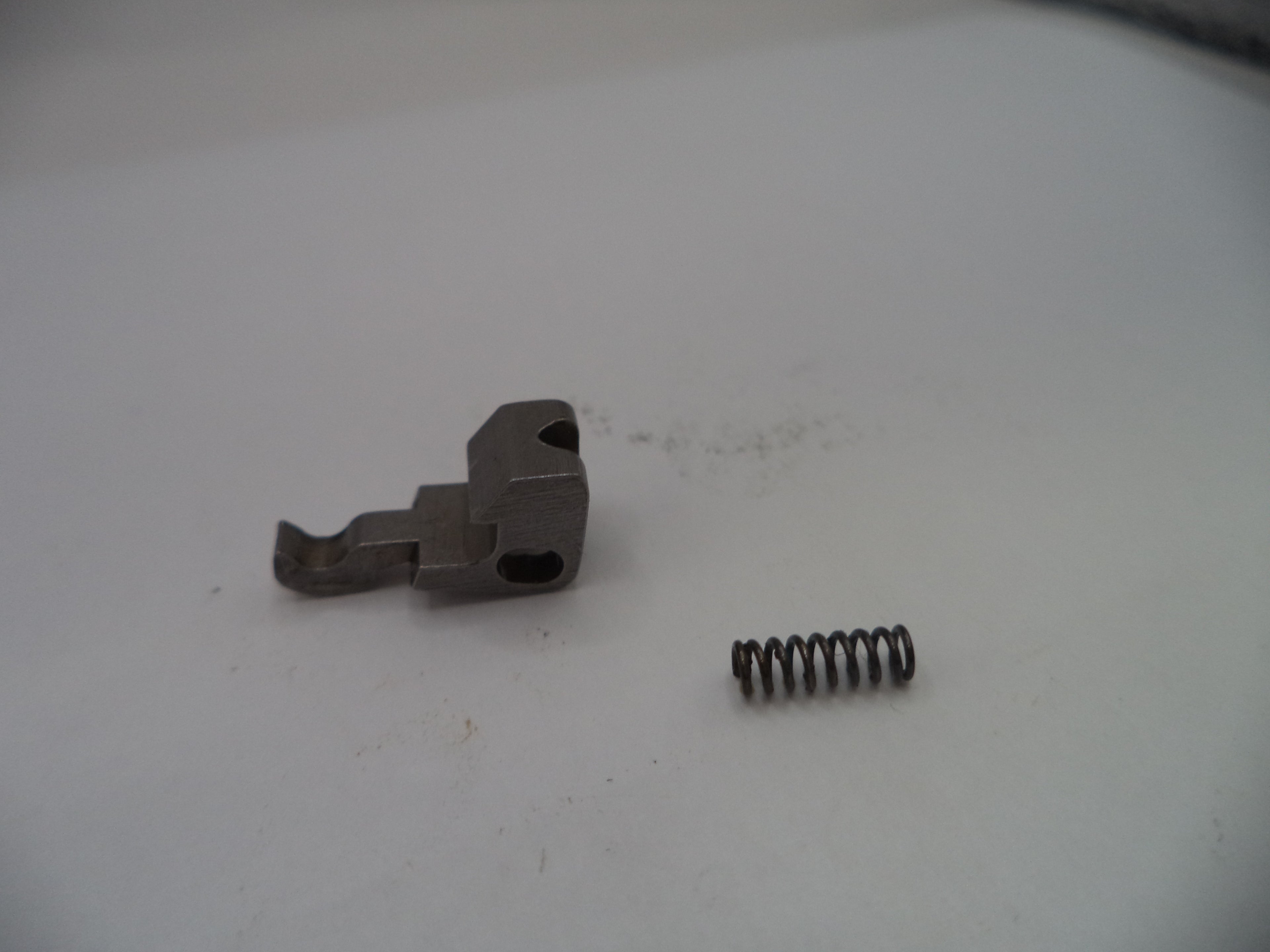 Metal component and spring on a white surface