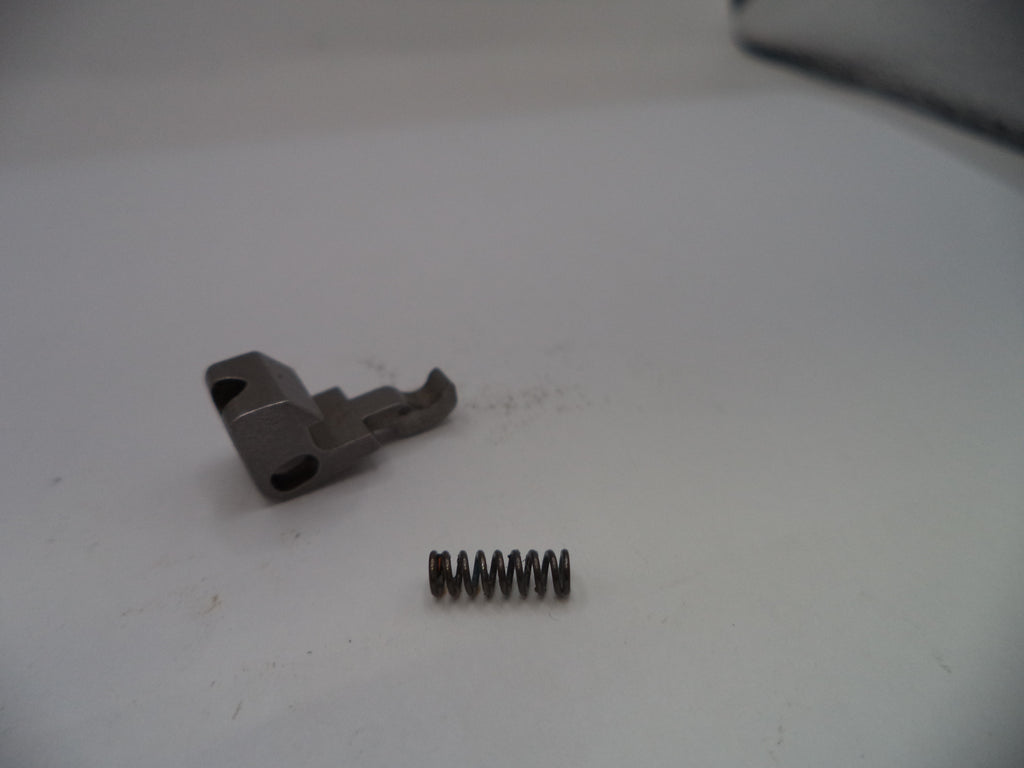 Metal component and spring on a white surface