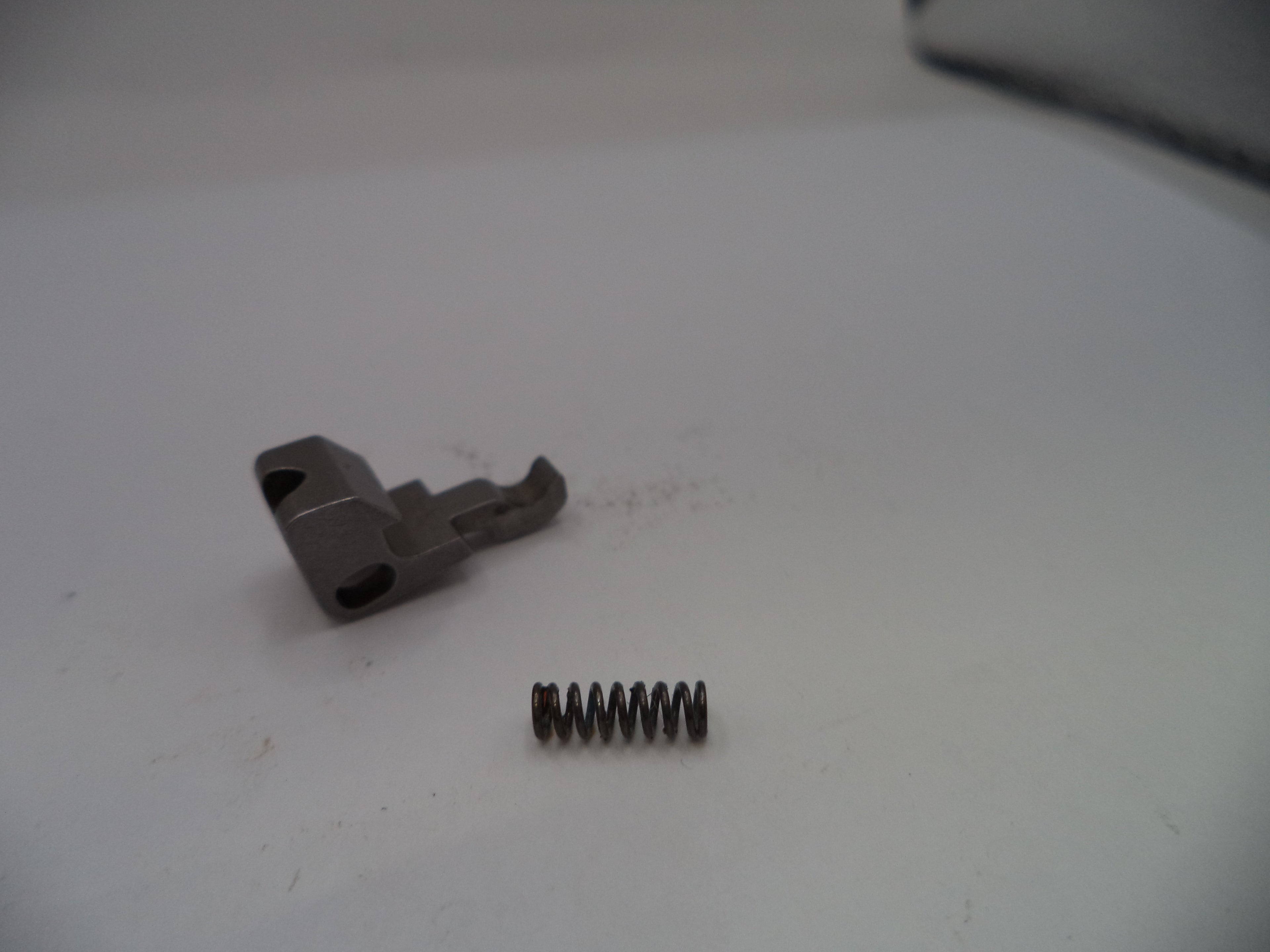 Metal component and spring on a white surface