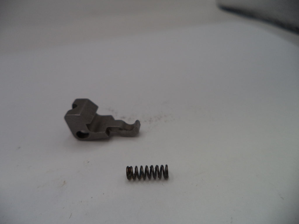 Metal component and spring on a white surface