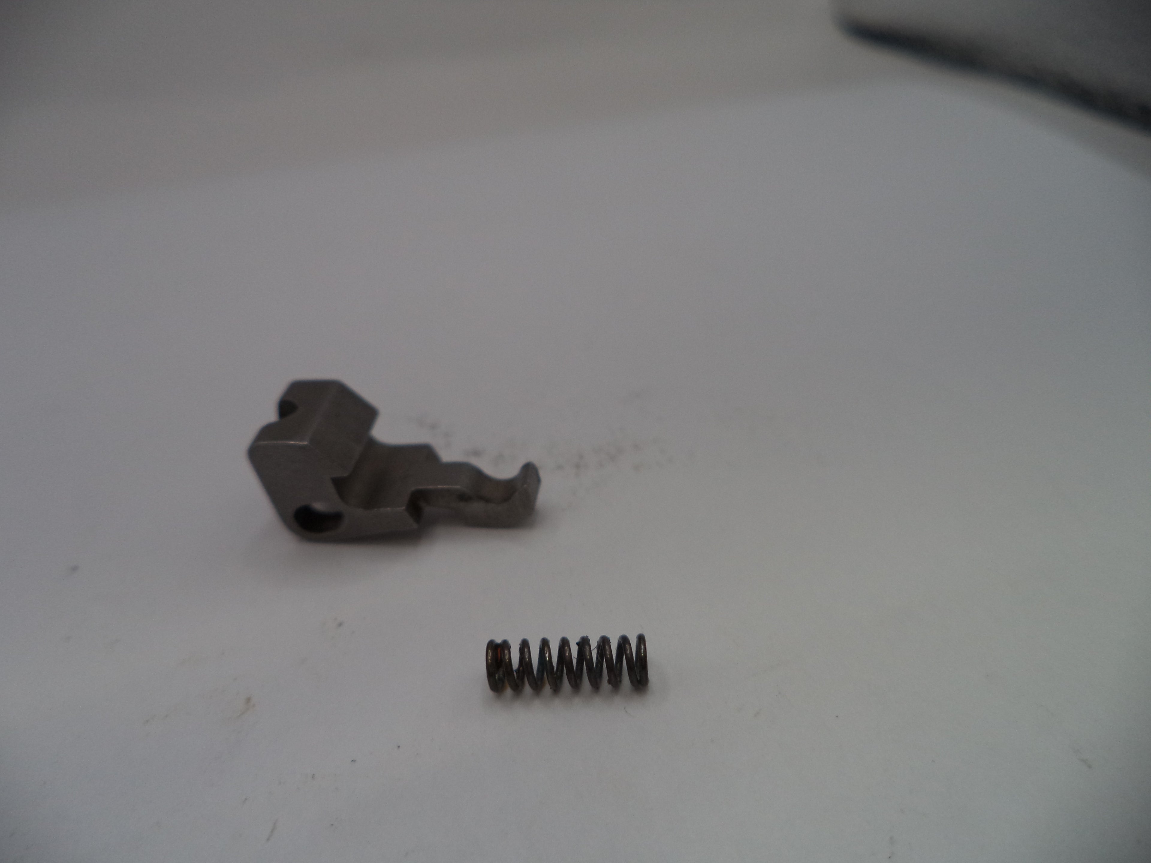 Metal component and spring on a white surface