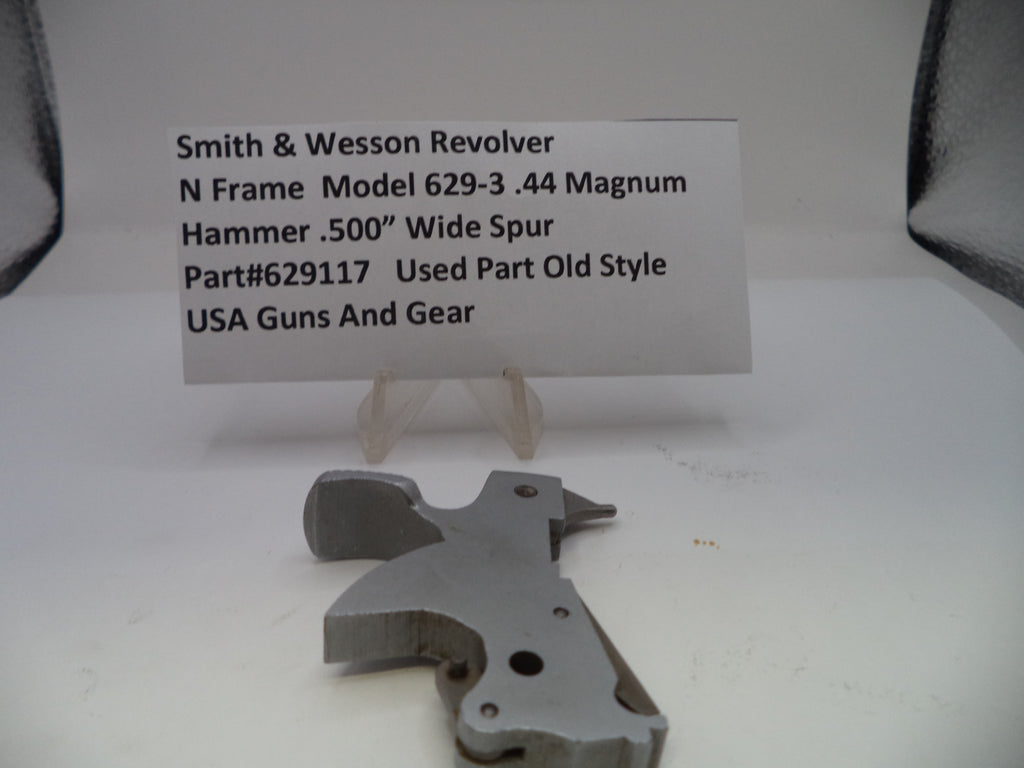 Metal gun part with descriptive card on a white background