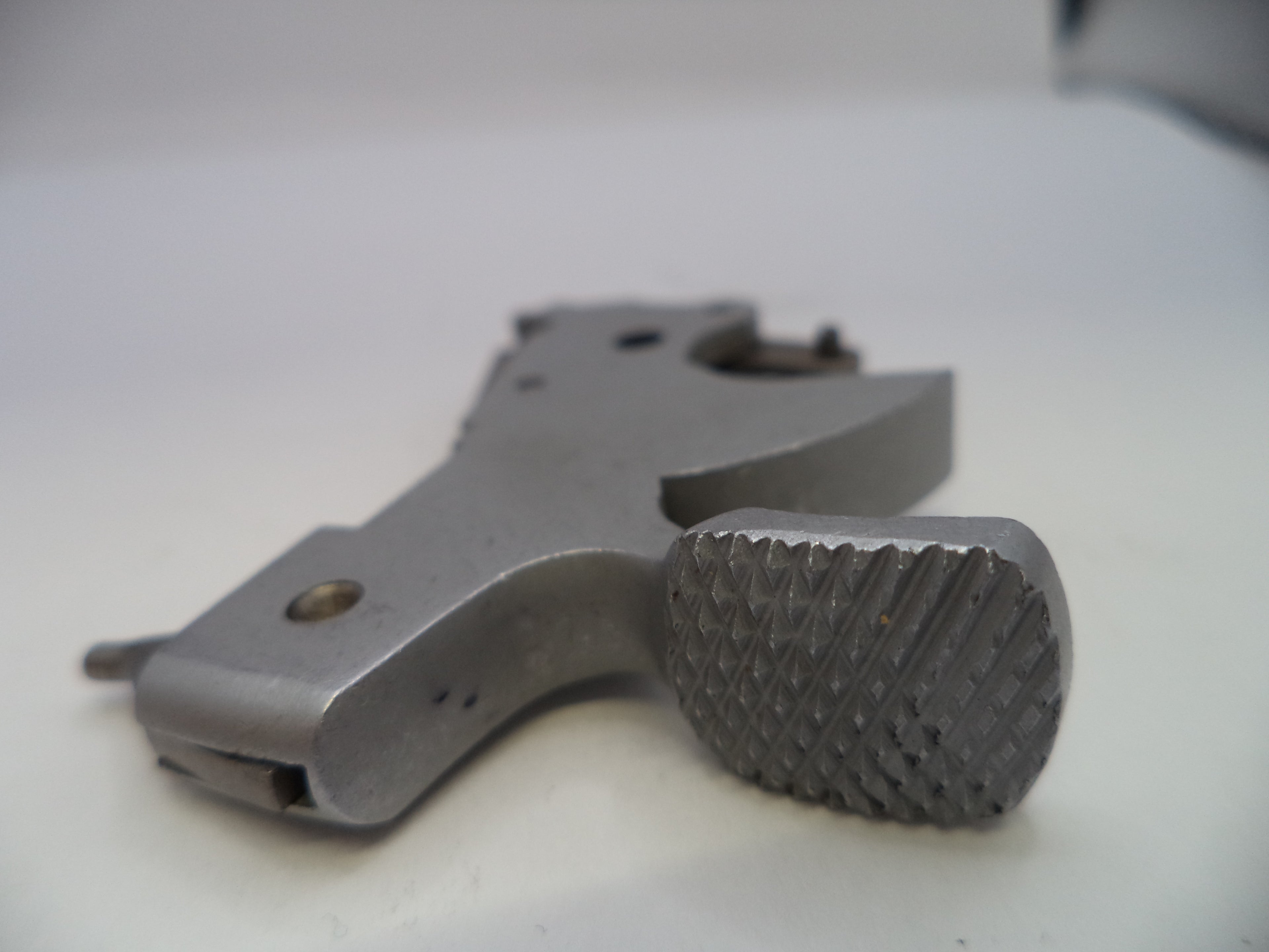 Metal gun trigger on a white background