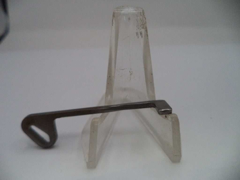 Metal tool on a clear plastic stand against a white background