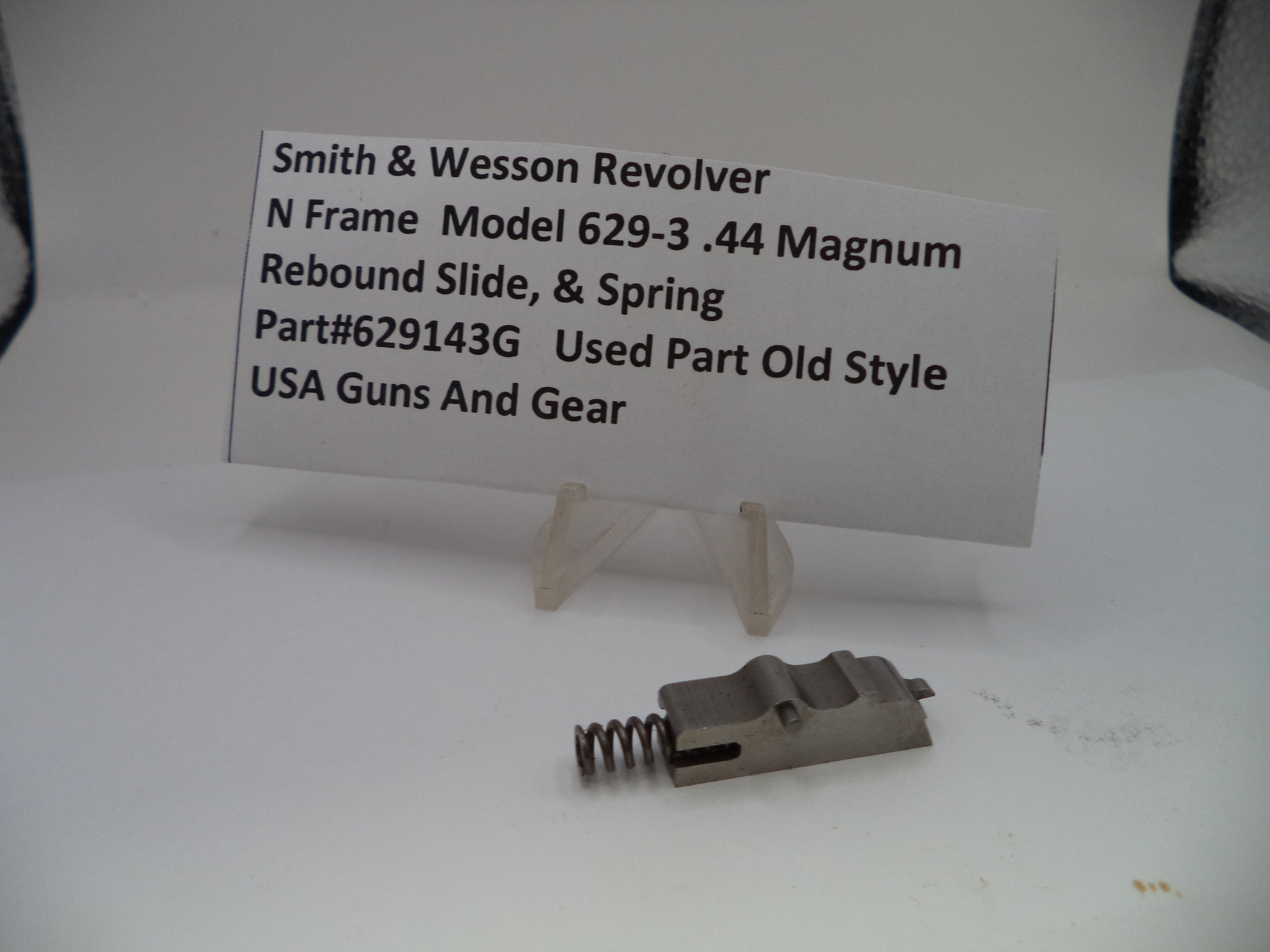 Smith & Wesson revolver part with a label on a white background