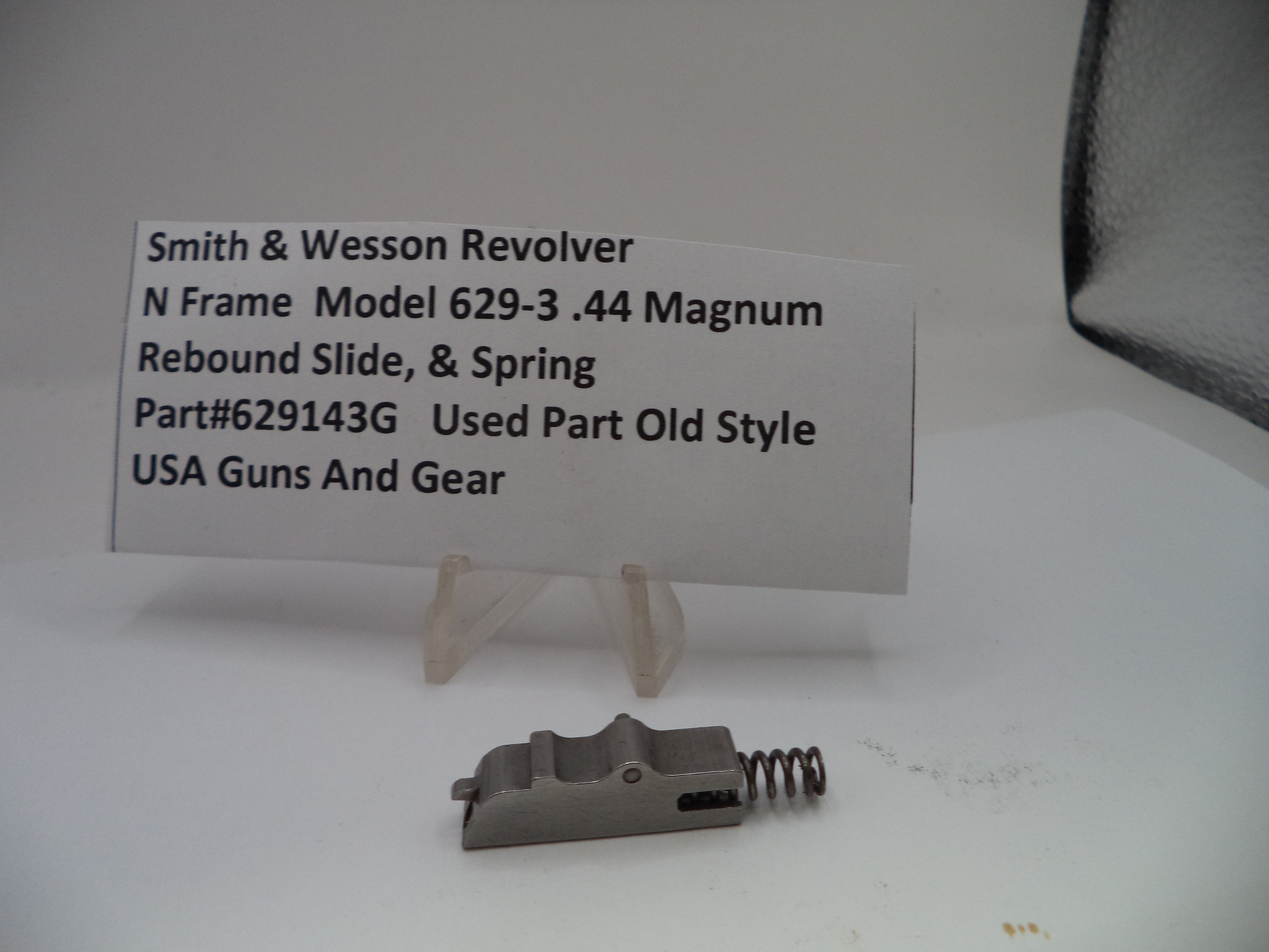 Smith & Wesson revolver part with descriptive card on a white background