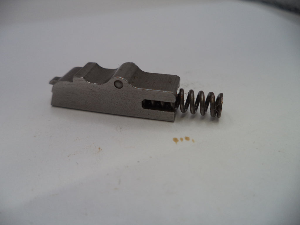 Metal component with a spring on a white surface