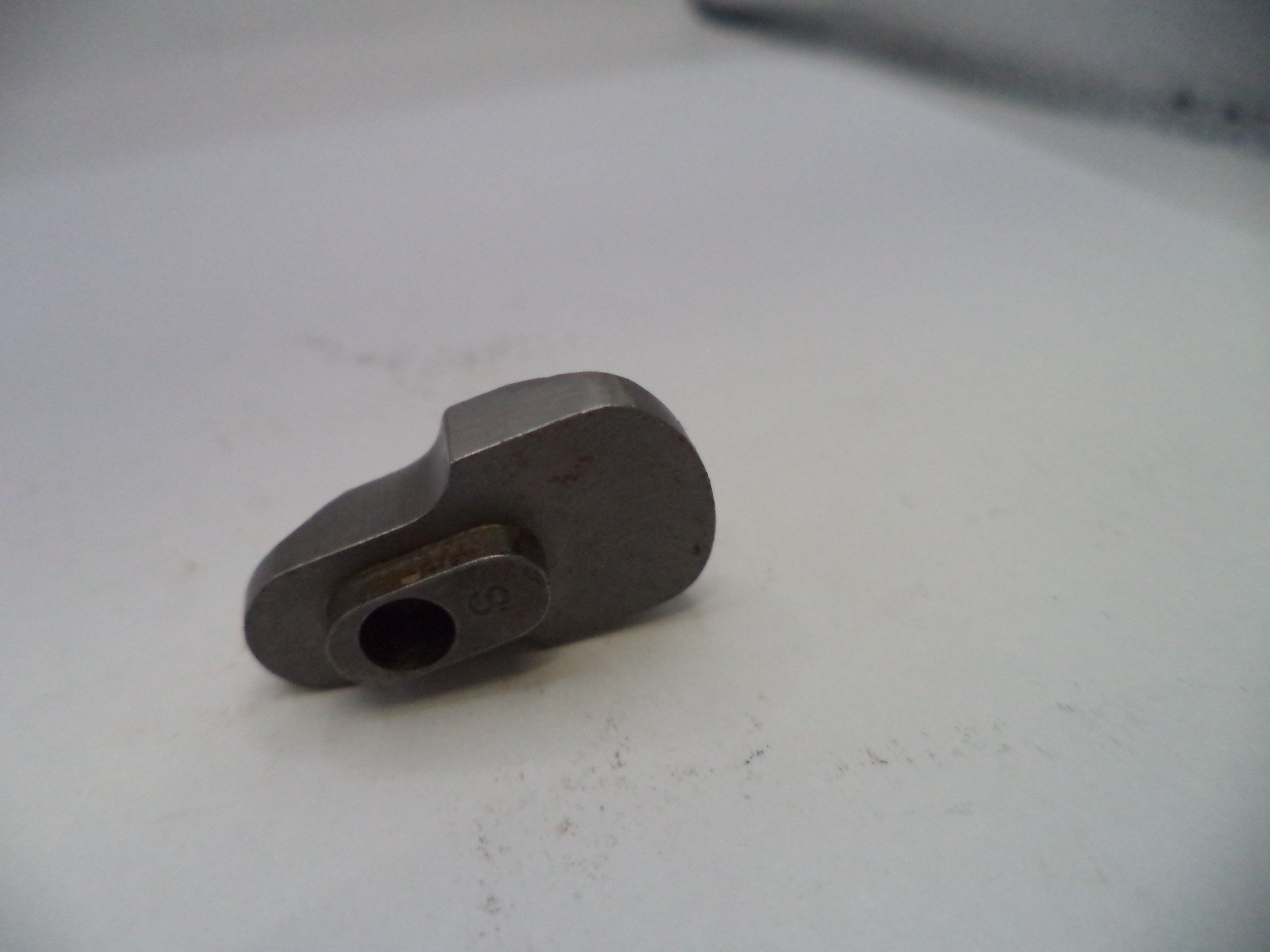 Metal tool or component on a white surface