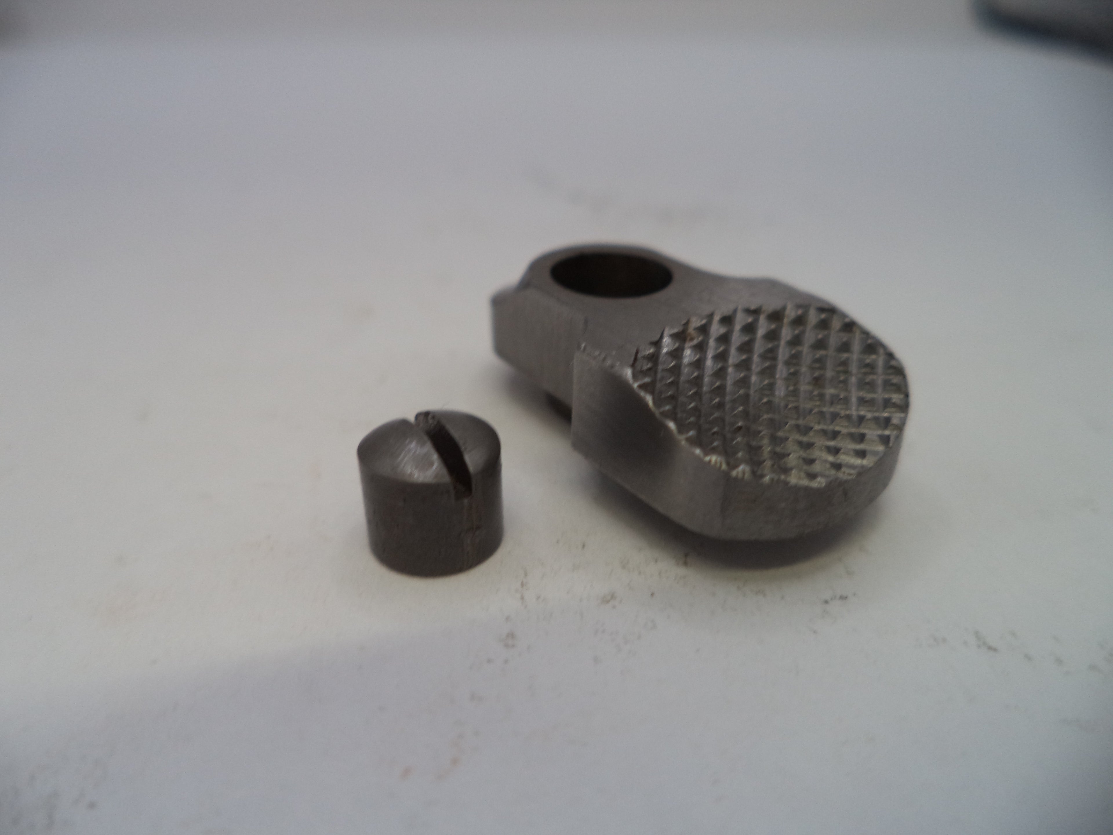 Two metal components on a white surface
