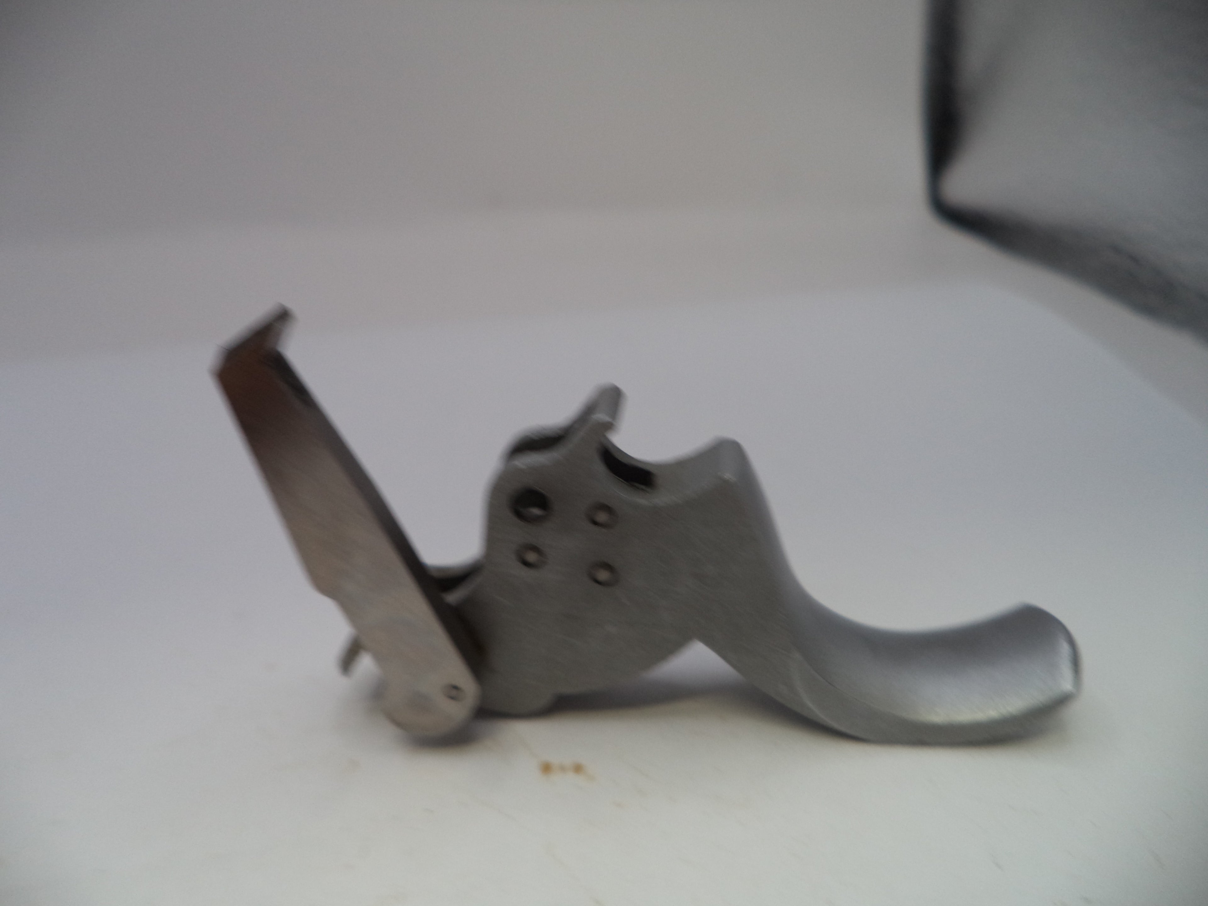 Metal gun trigger on a white background