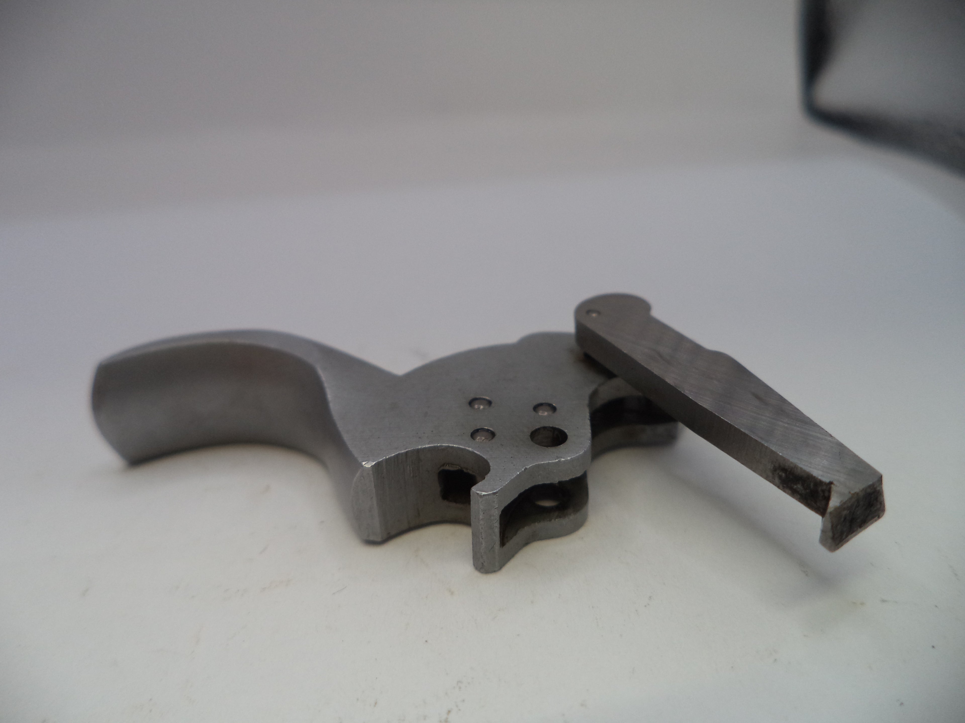 Metal gun trigger on a white background