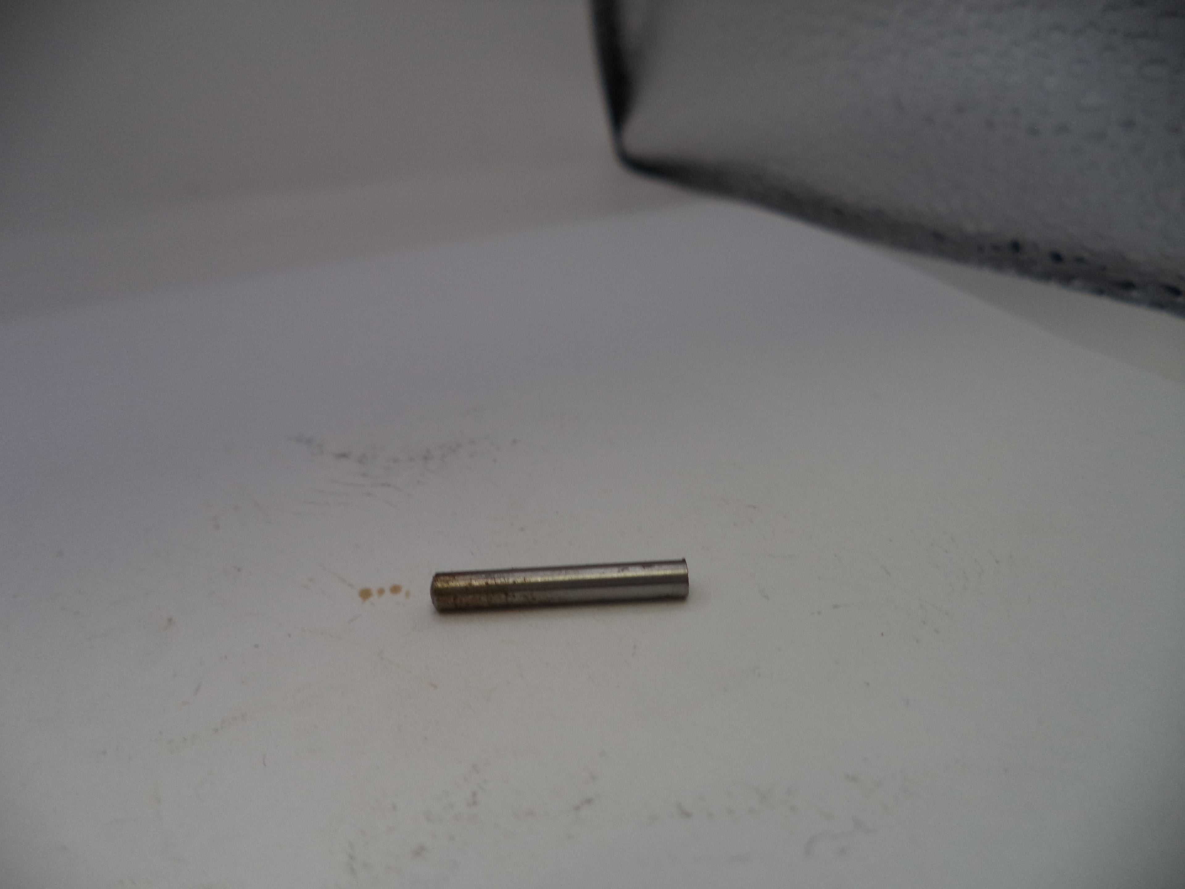 Small cylindrical metal object on a white surface
