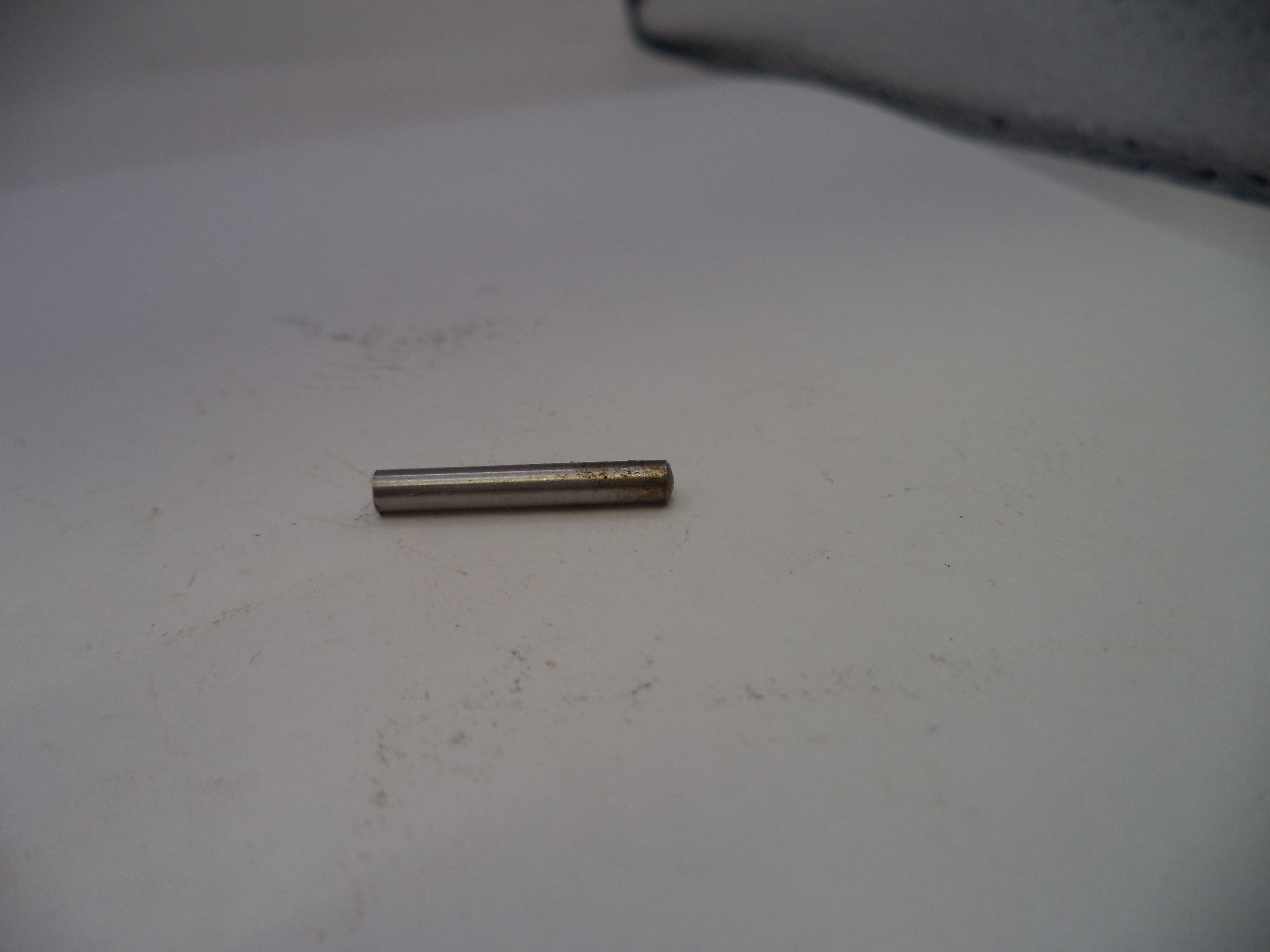 Small cylindrical metal object on a white surface