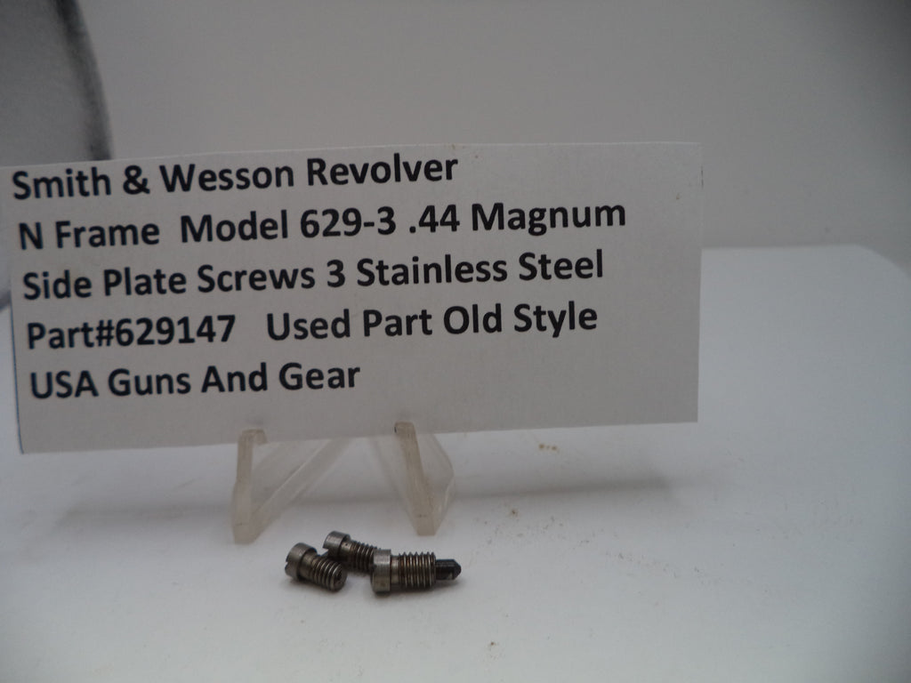 Three stainless steel screws on a white surface with a label about Smith & Wesson Revolver side plate screws.