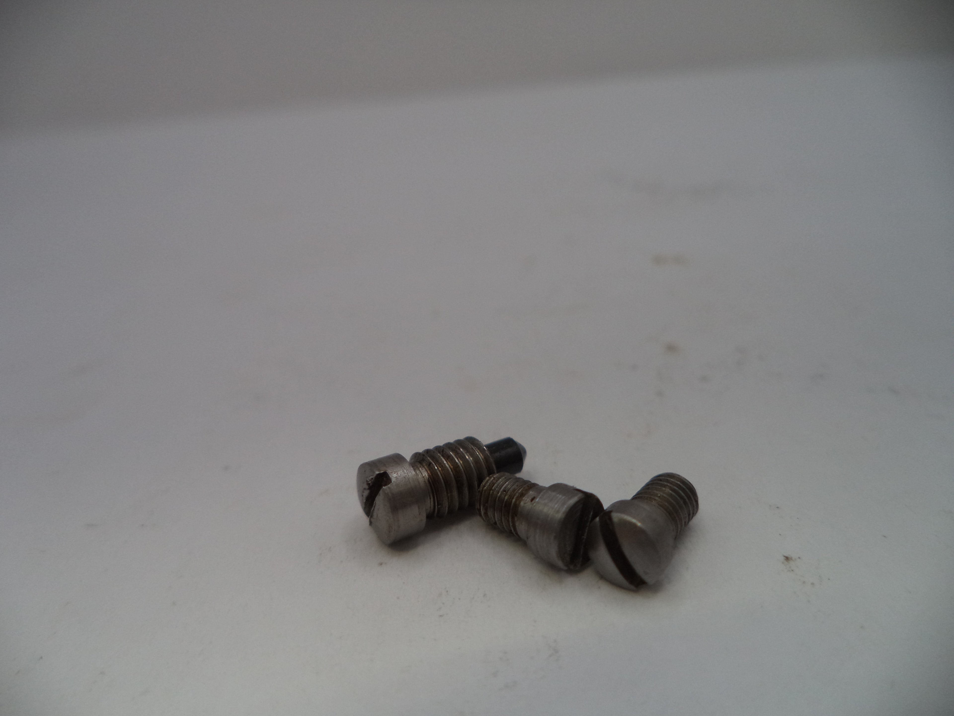 Three metal screws on a white surface