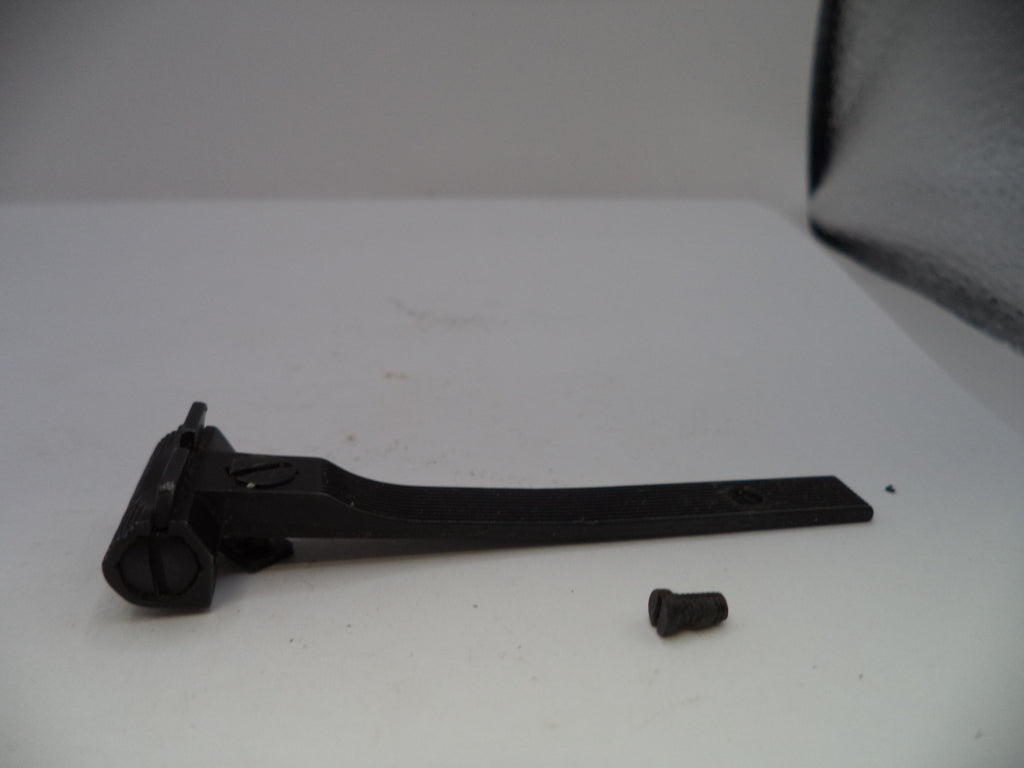 Black metal lever and screw on a white surface with a gray background