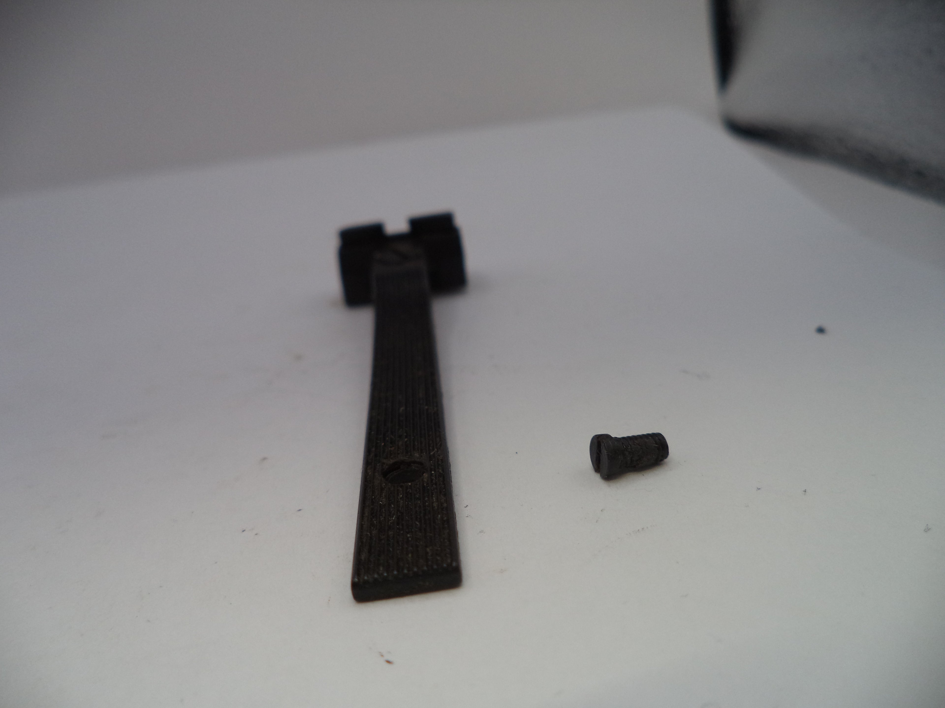 Black metal bracket and screw on a white surface