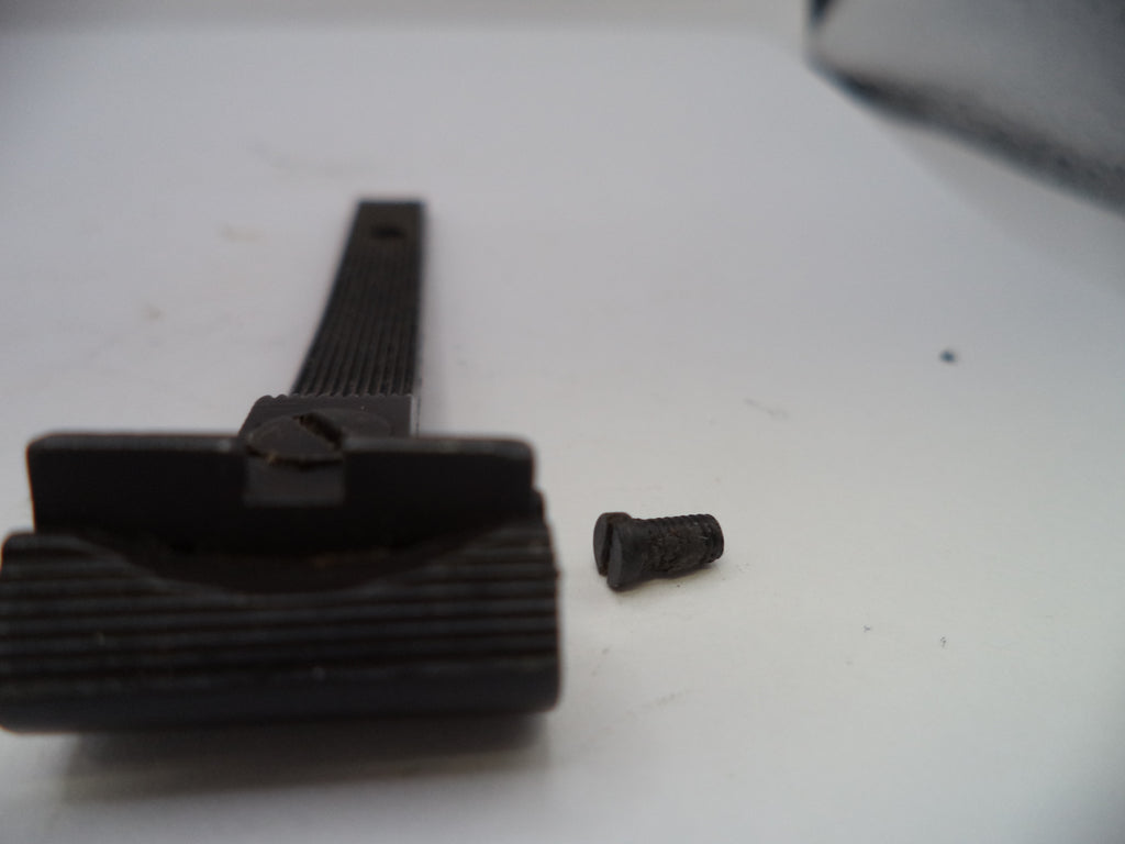 Black rubber gasket and screw on a white surface