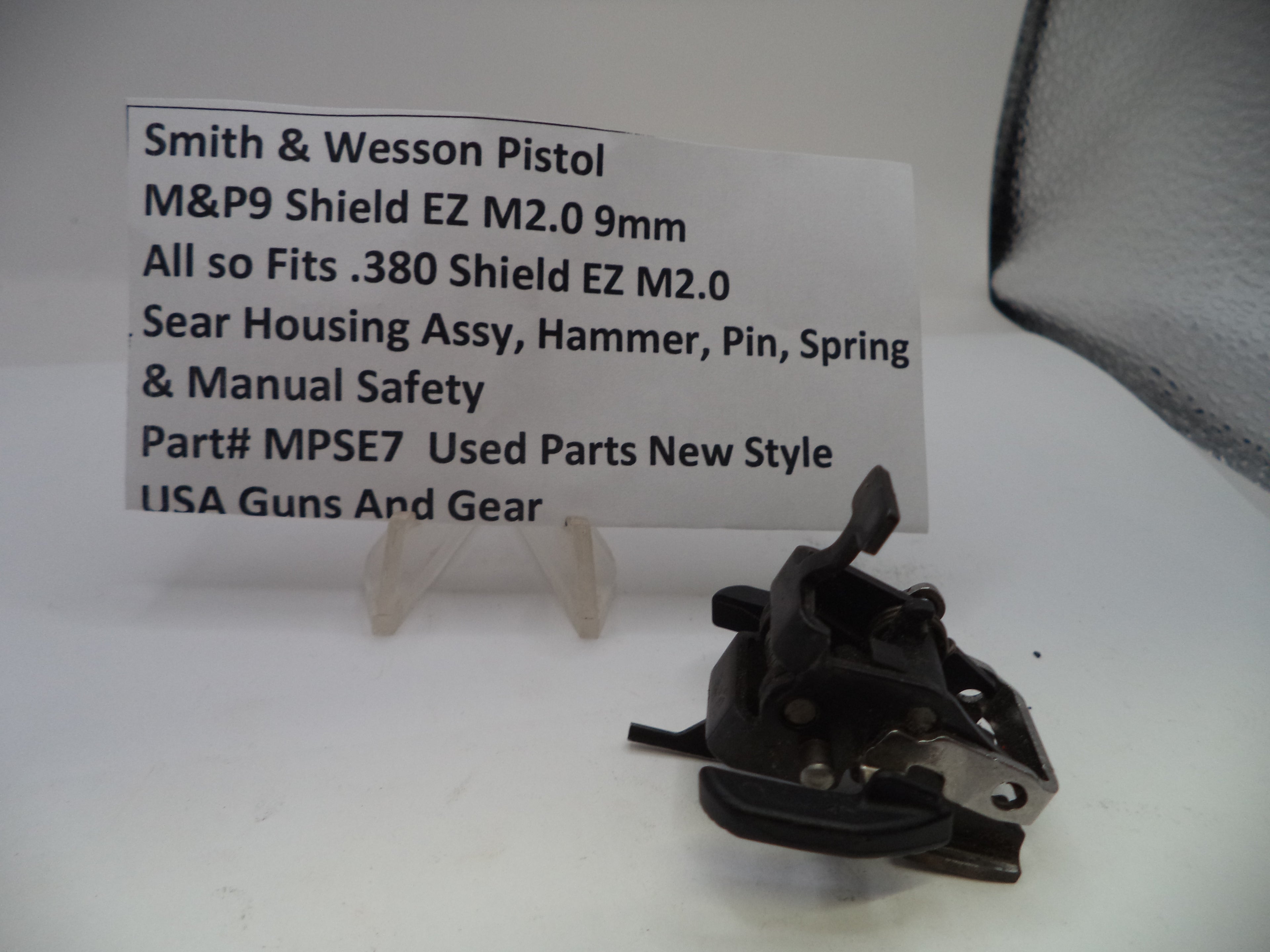 Smith & Wesson pistol part on a white background with a label.
