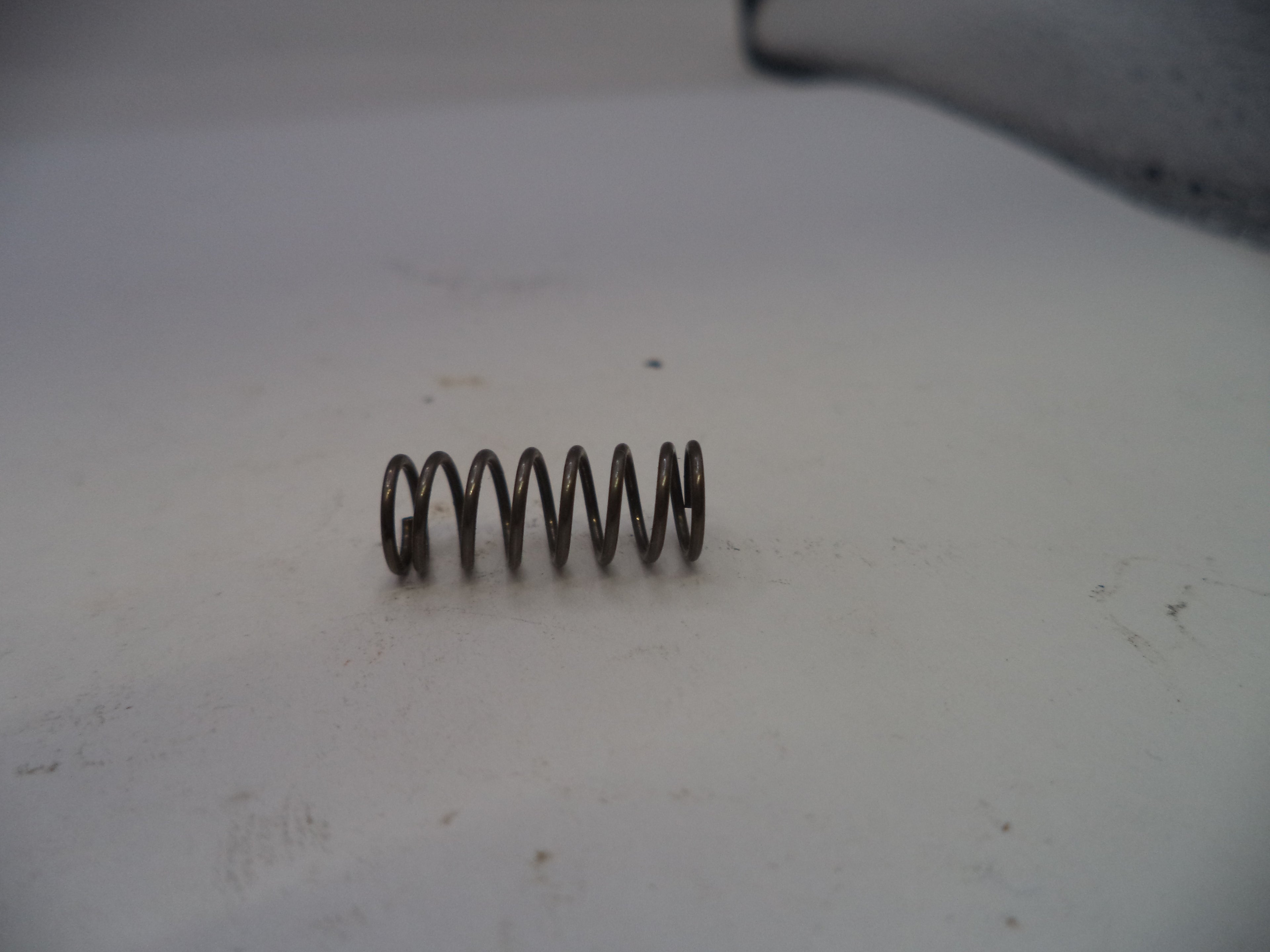 Coiled spring on a white surface