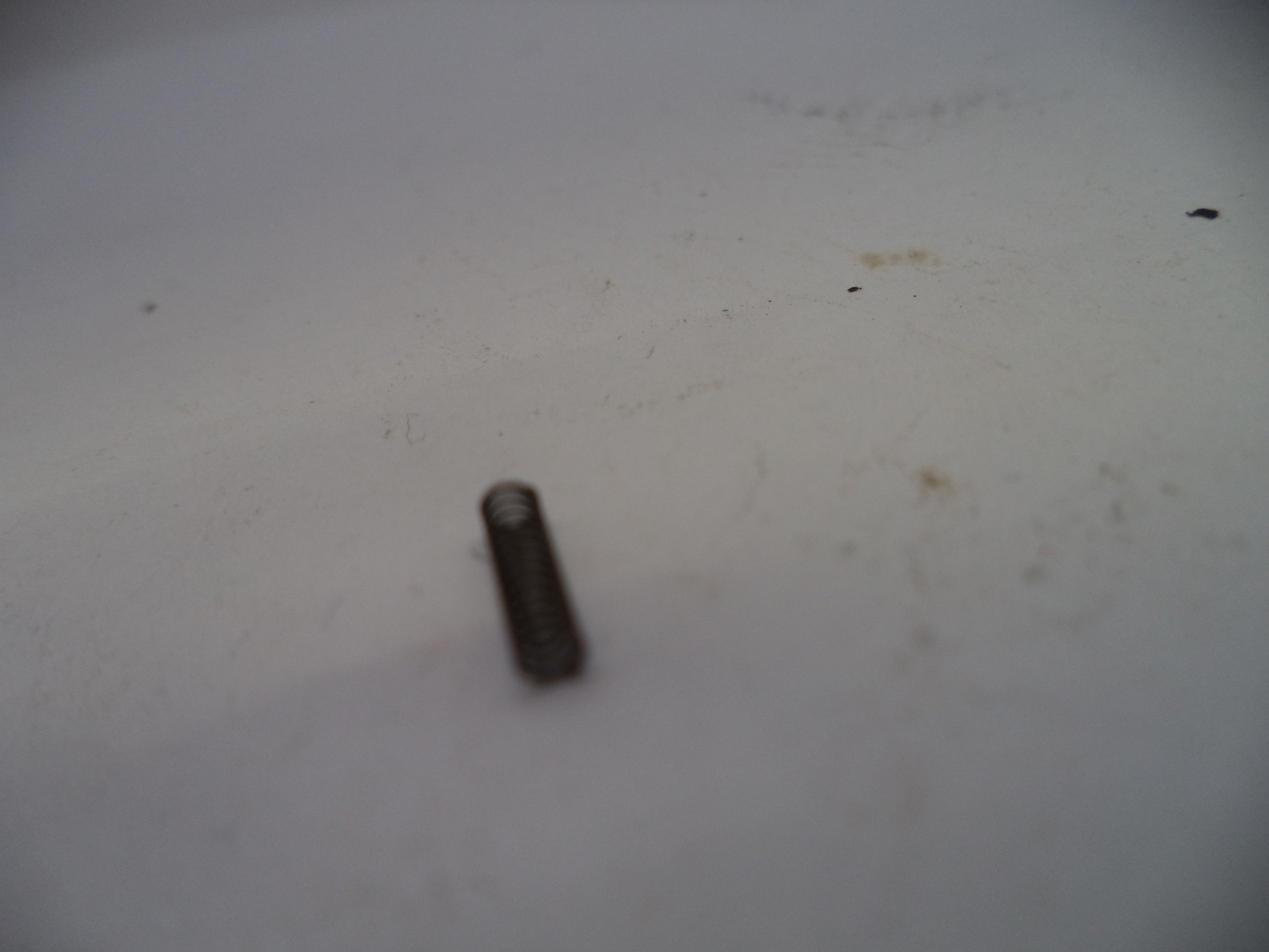 Small cylindrical object on a textured white surface