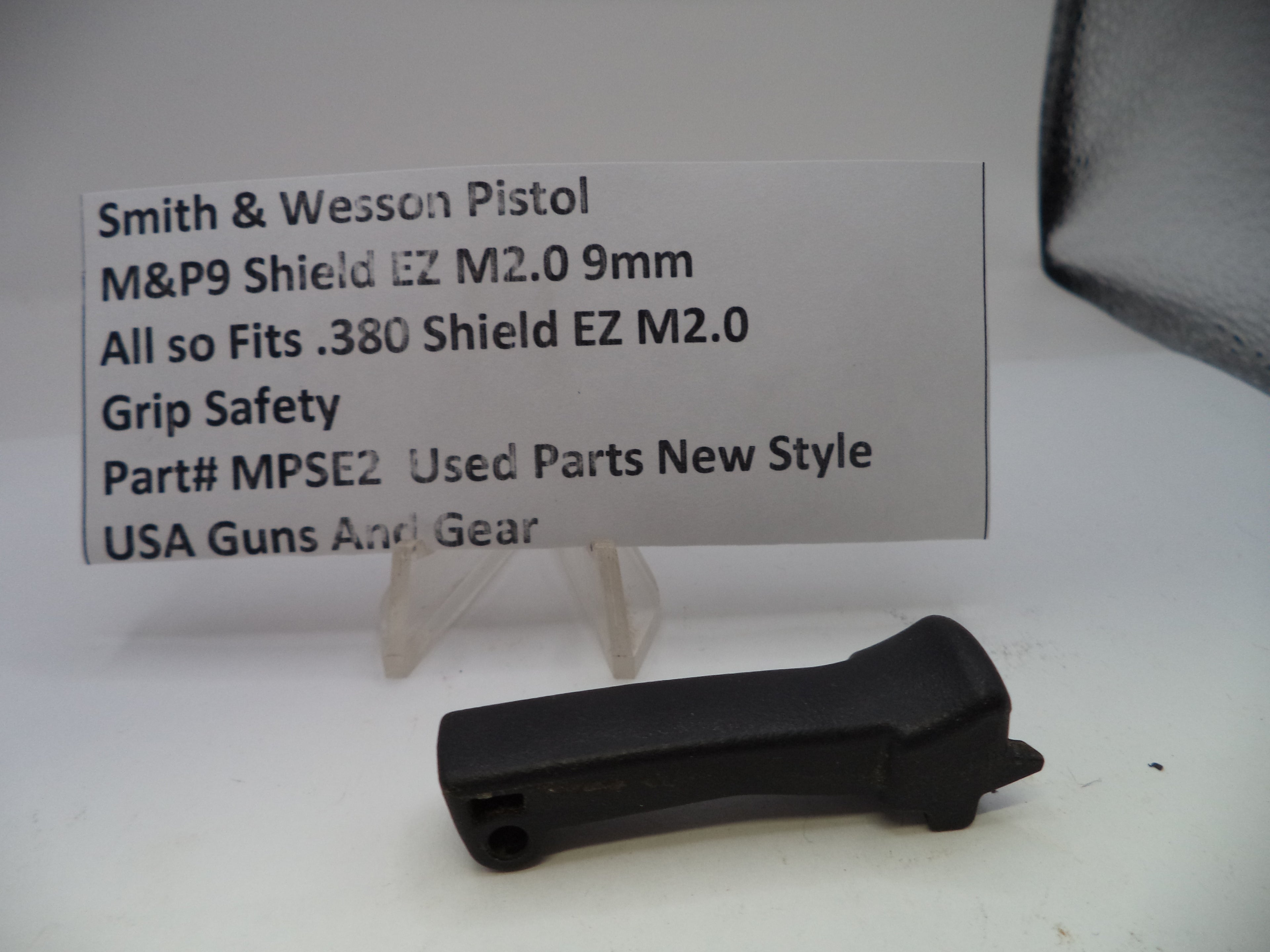Black grip safety for Smith & Wesson pistol on a white background with a label.