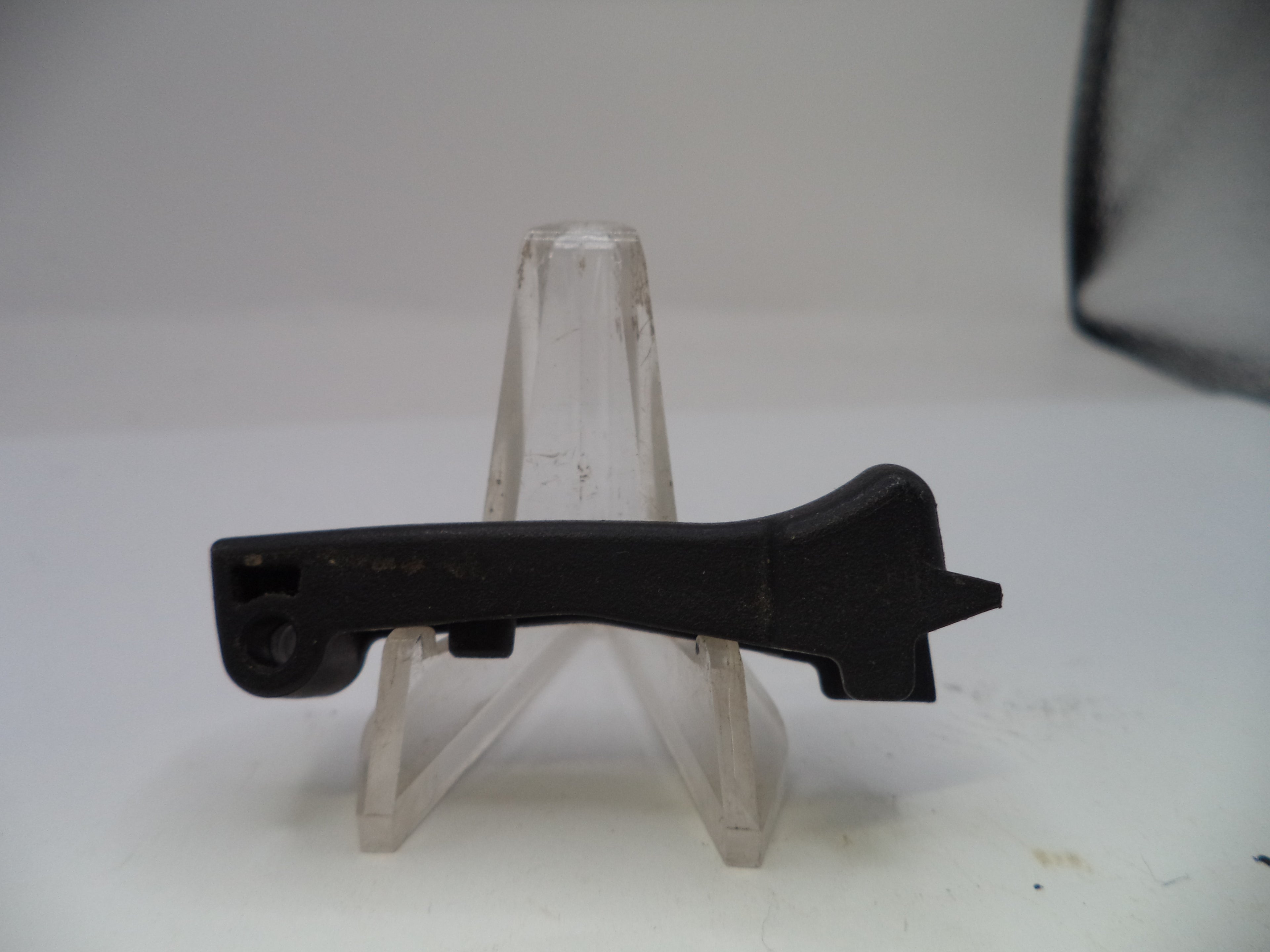 Black metal bracket on a clear stand against a white background