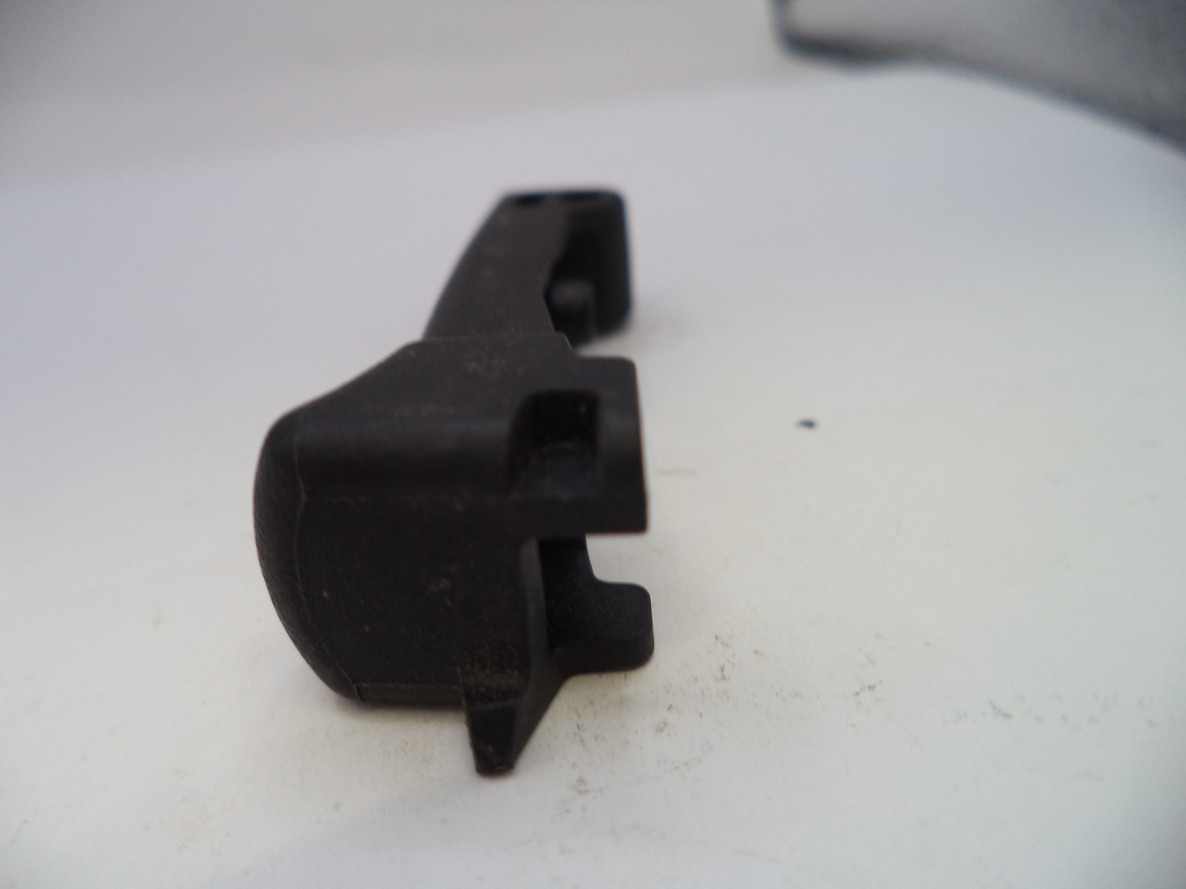 Black plastic component on a white surface
