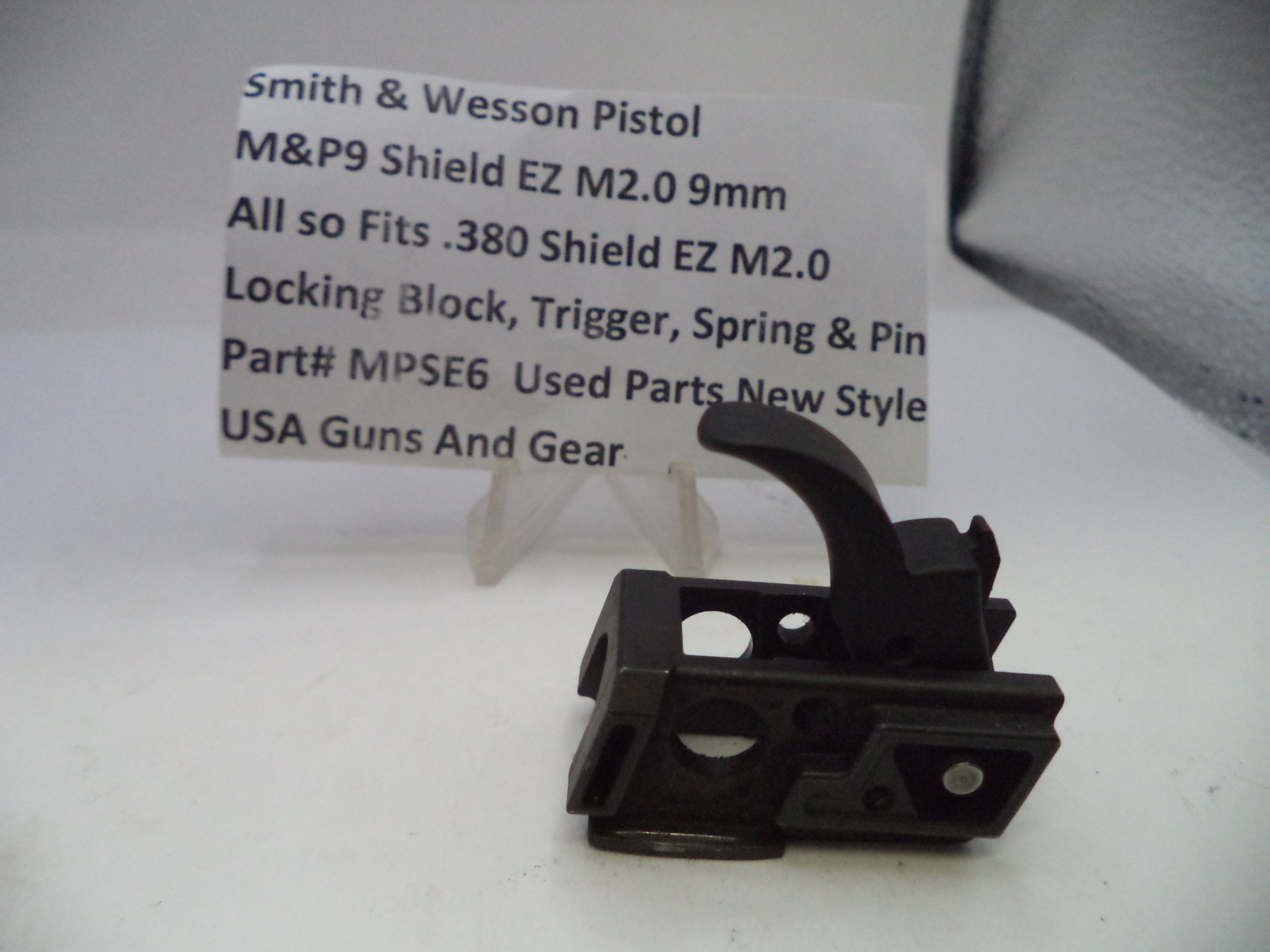 Black gun part with a label on a white background