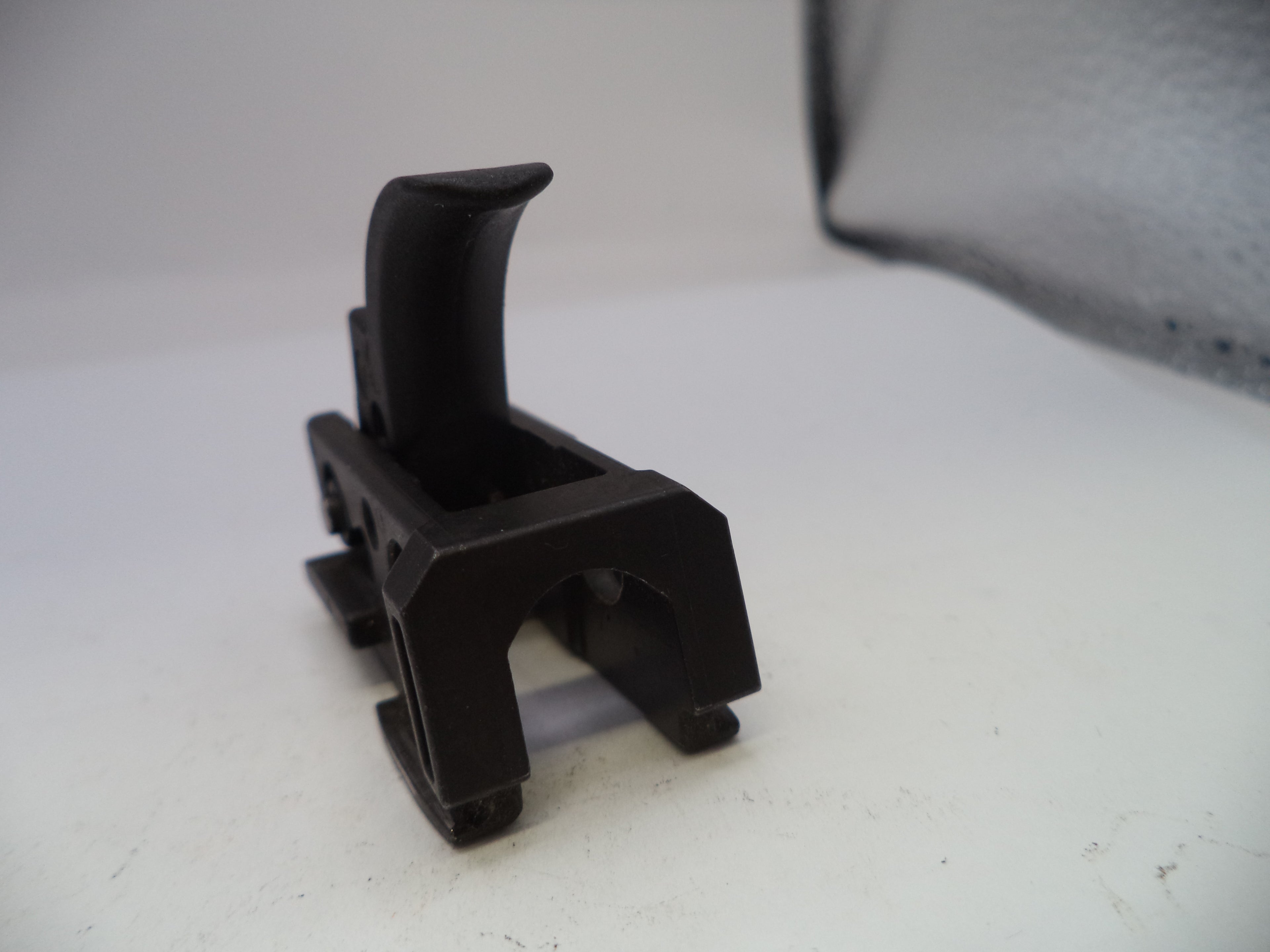 Black plastic component on a white surface