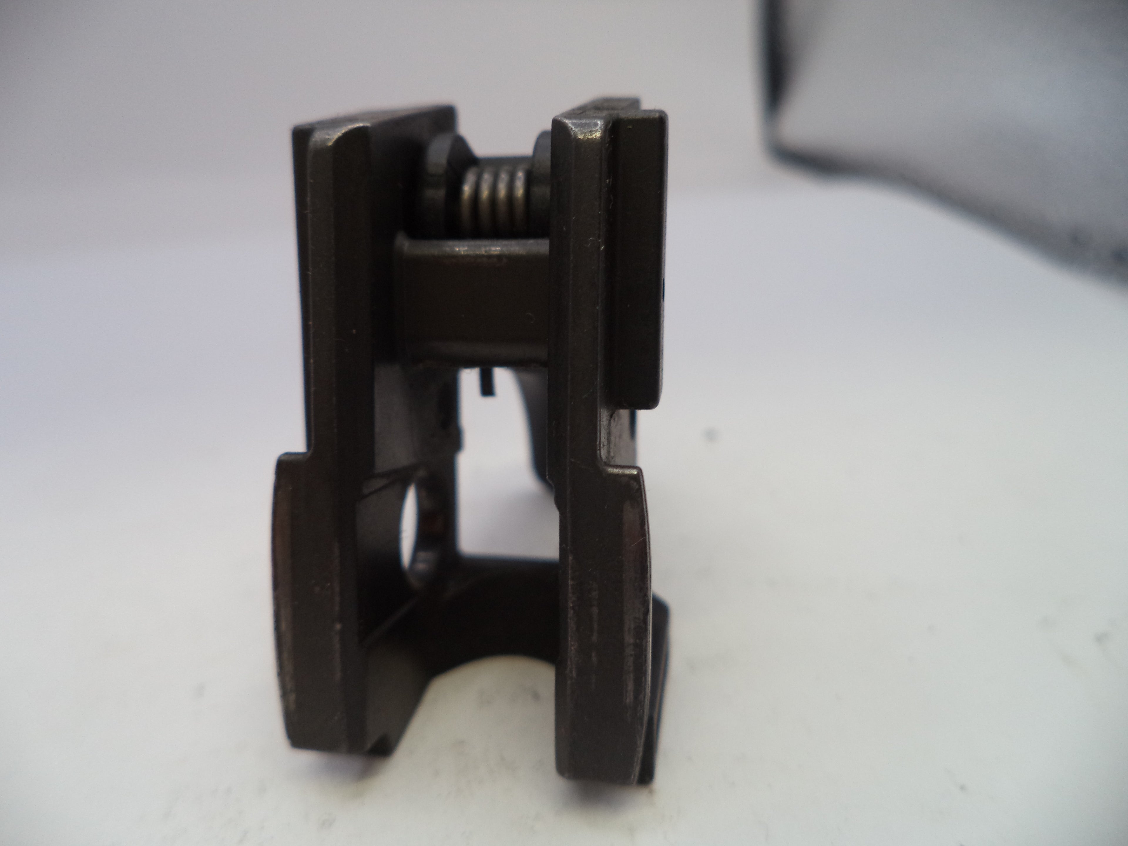 Close-up of a black metal clamp on a white surface