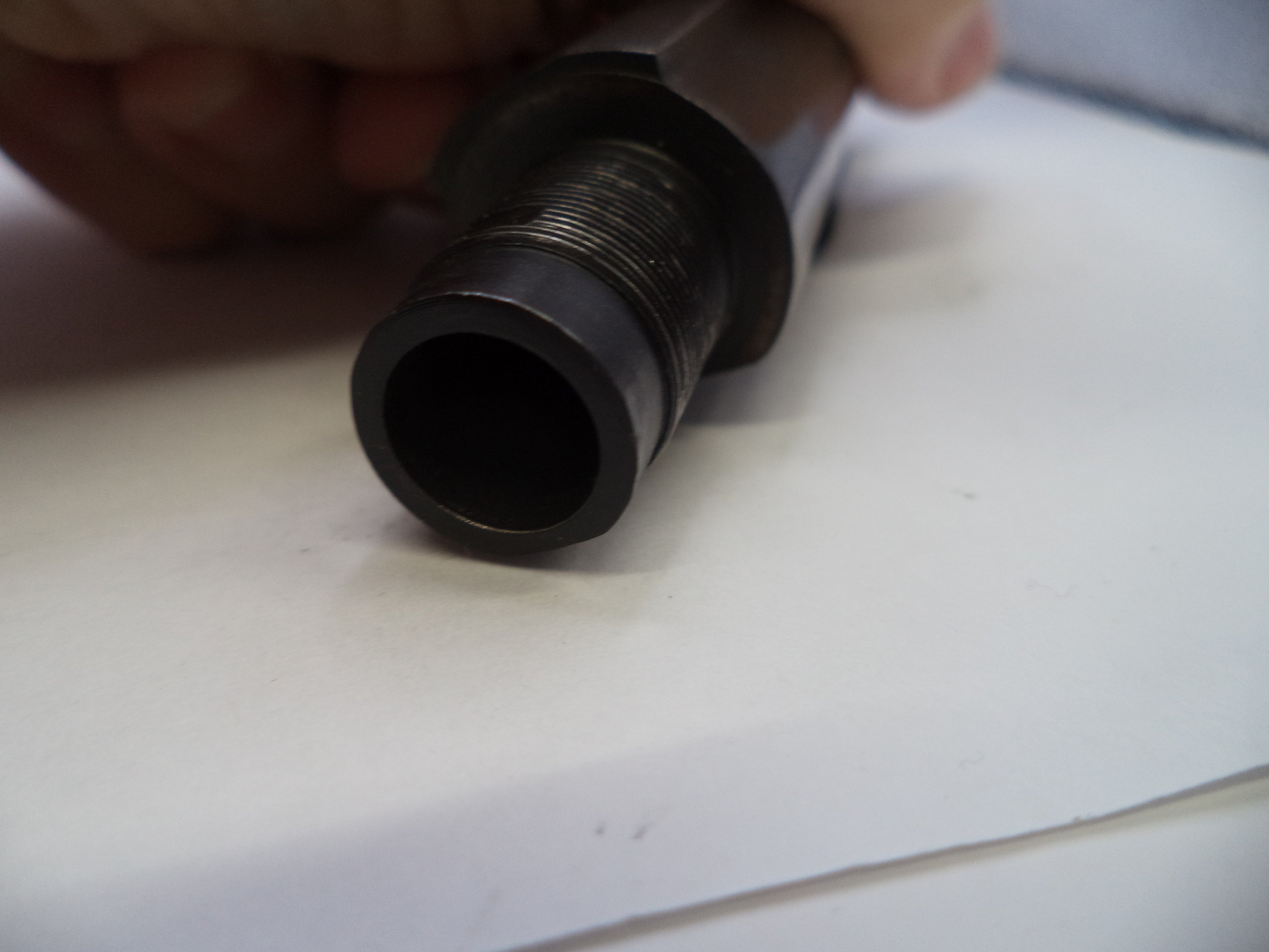 Close-up of a cylindrical metal object on a white surface