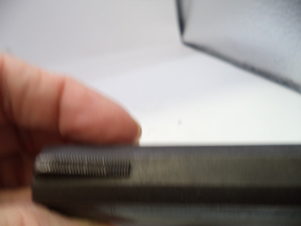 Close-up of a textured black object held by a hand with a blurred background