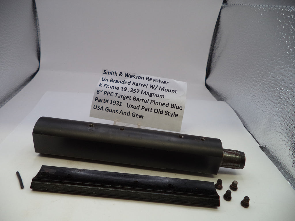 Smith & Wesson revolver barrel with mounting hardware on a white surface with a label.