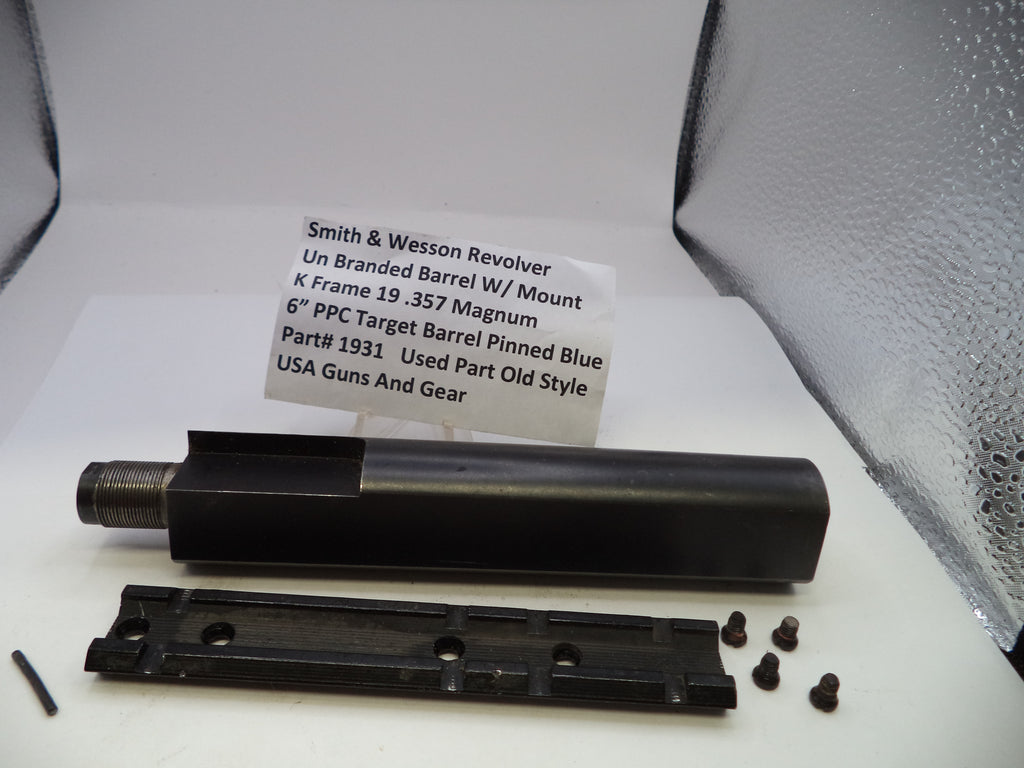 Smith & Wesson revolver barrel and parts on a white surface with a label.