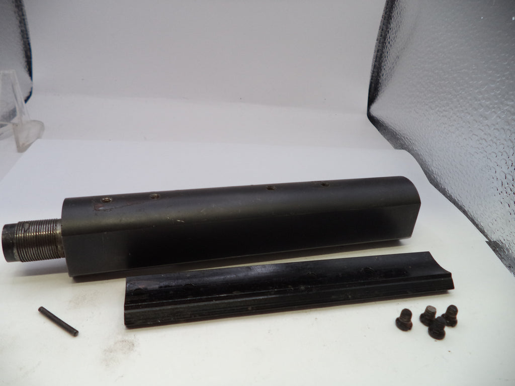 Black metal component with smaller parts on a white surface