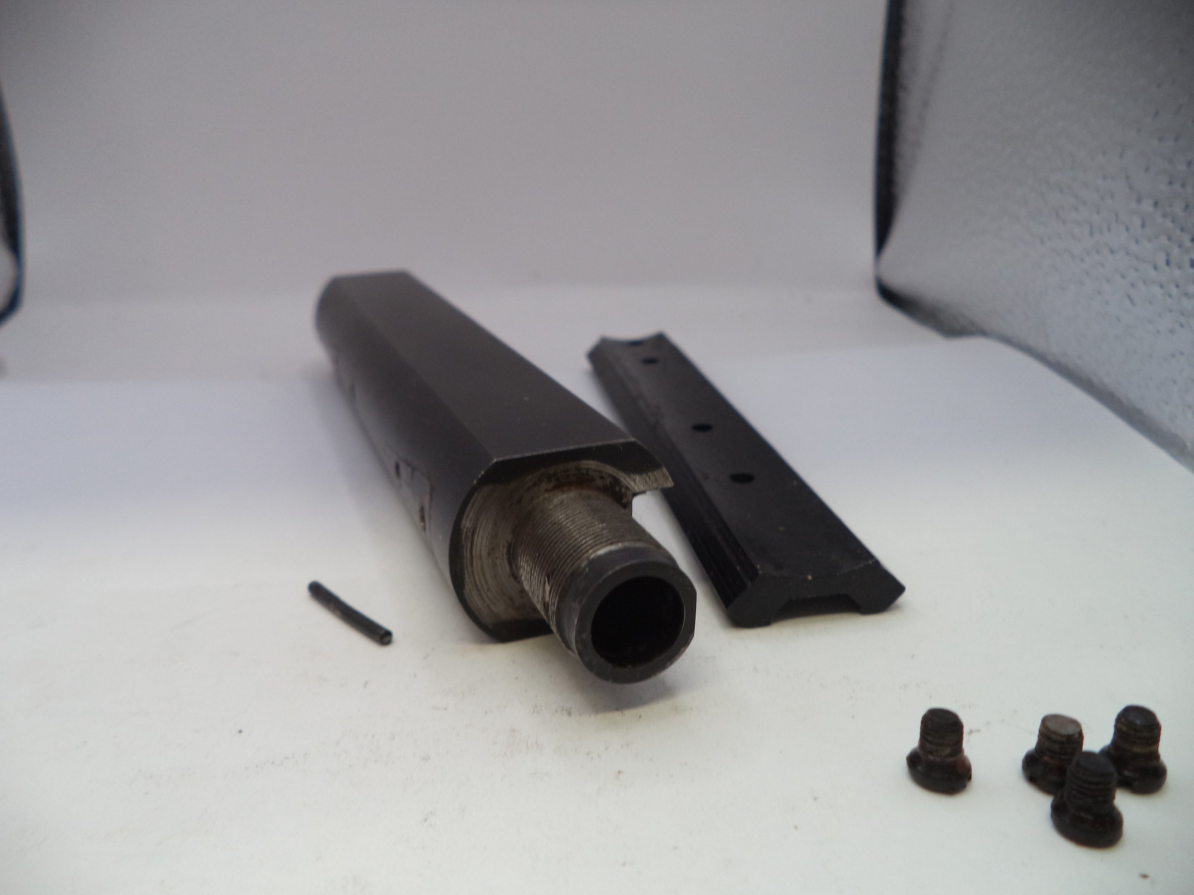 Metal components and screws on a white surface