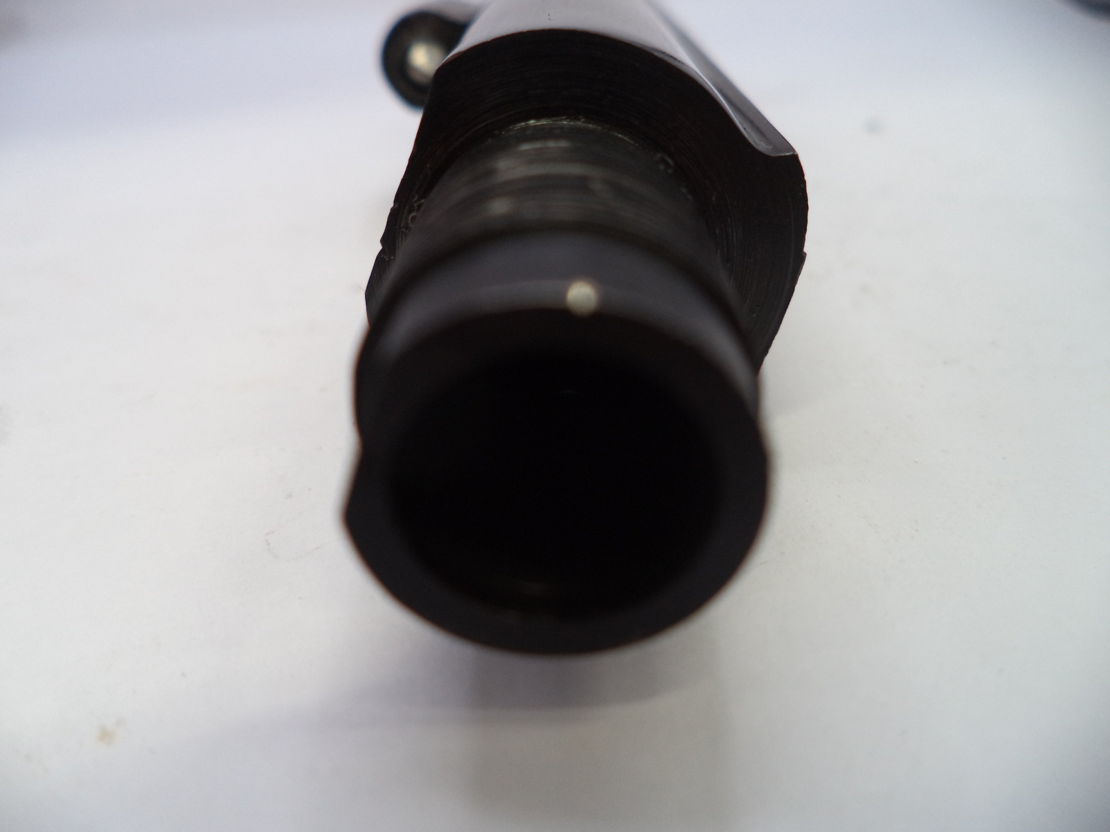 Close-up of a black cylindrical object on a white background