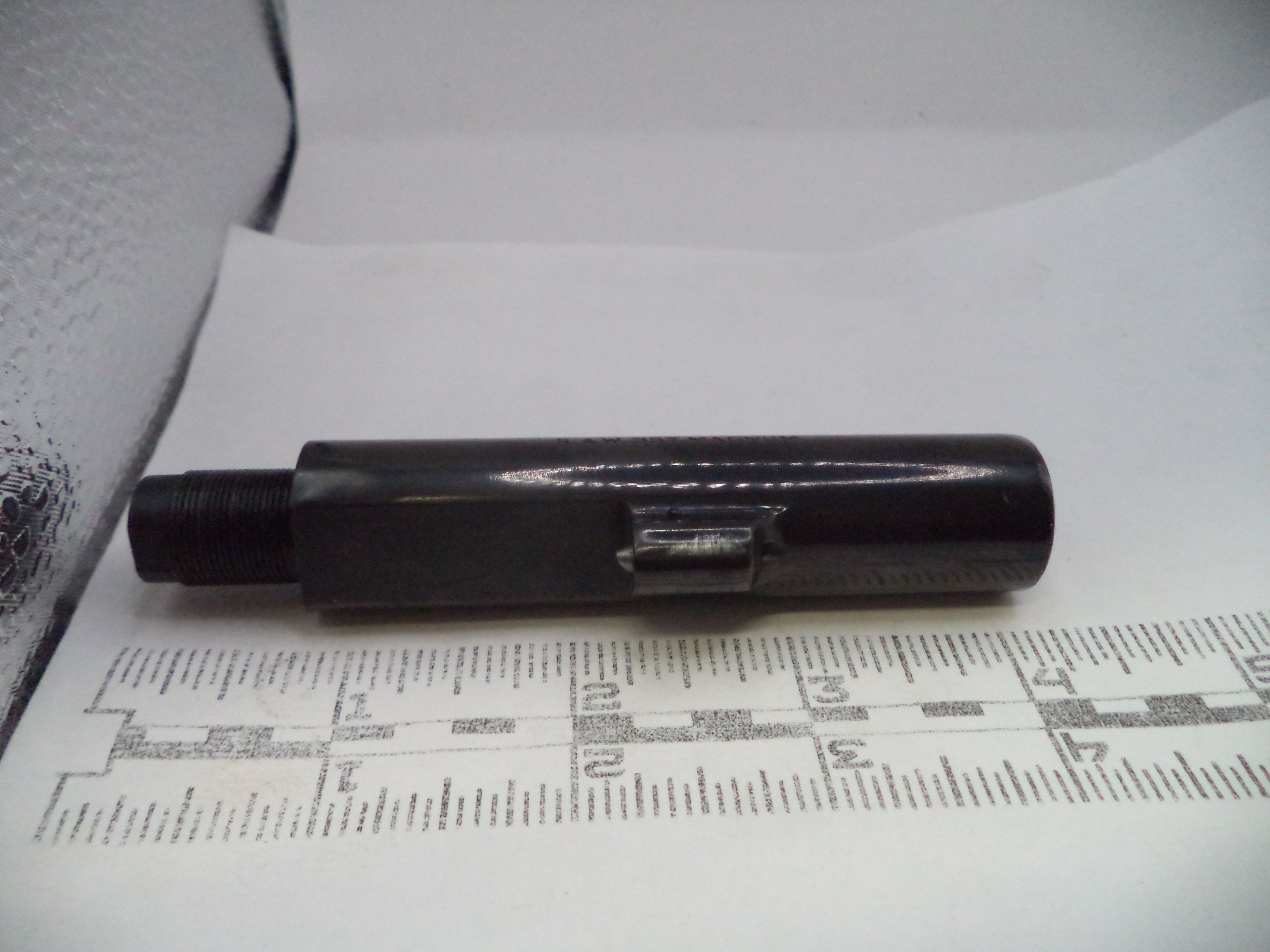 Black cylindrical object on a white surface with printed text